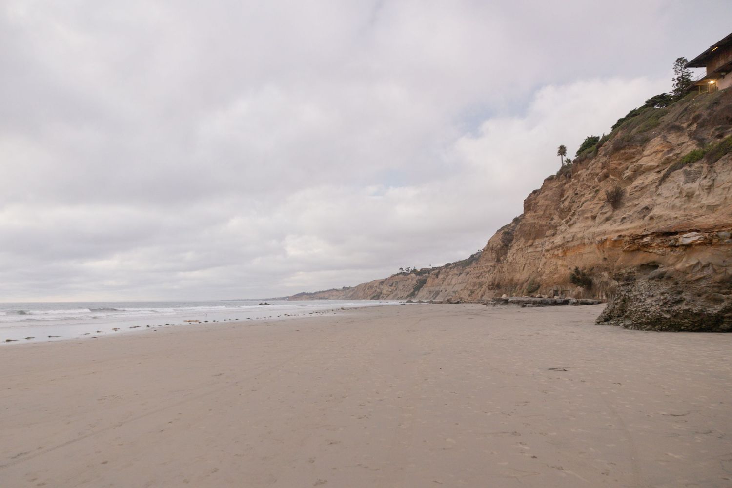 Photo of the beach at la Jolla Shores, with the sand and cliff/ocean.