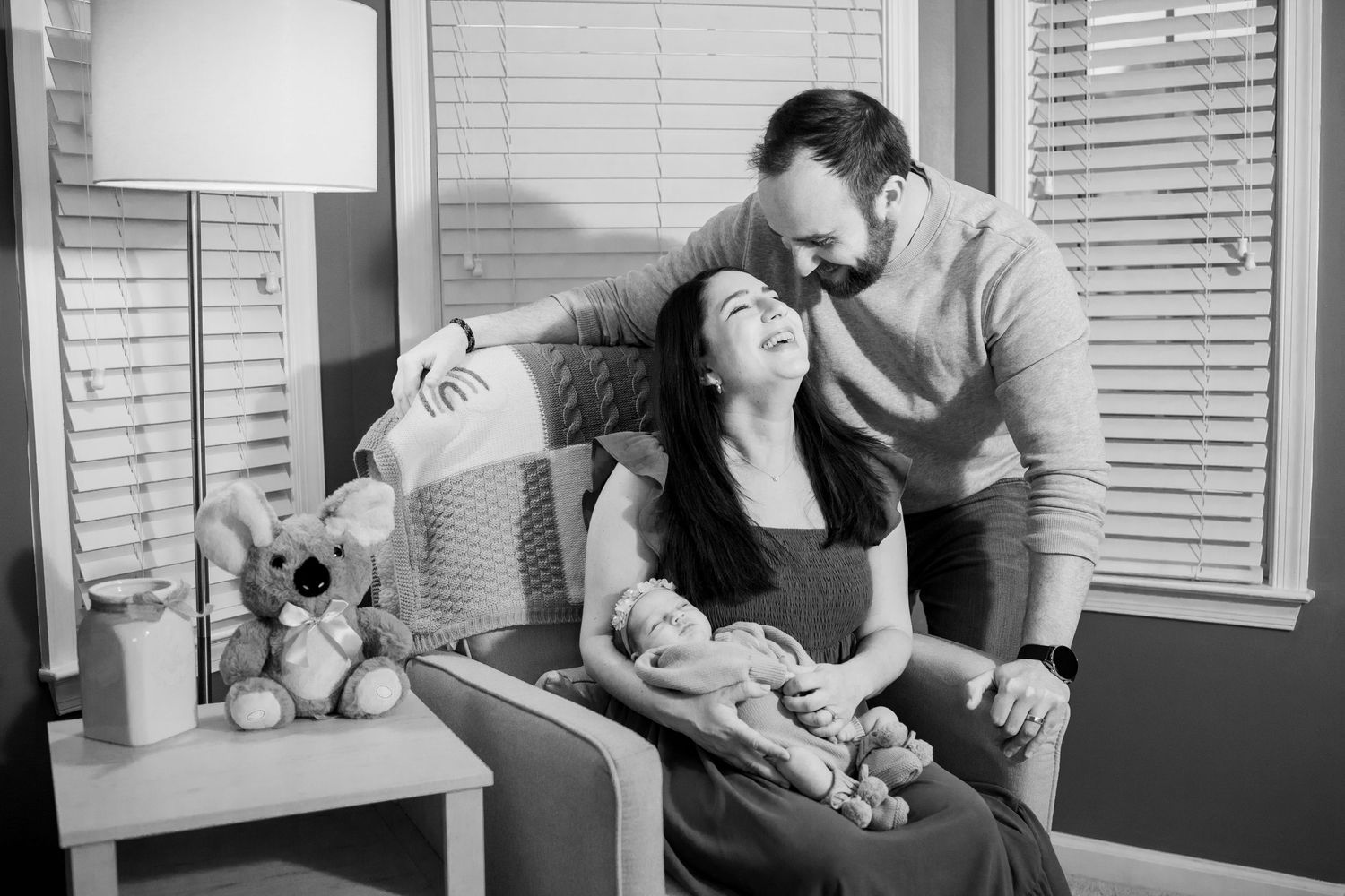 A tender series showing tender moments between parents and their sleeping baby in black and white home photos.