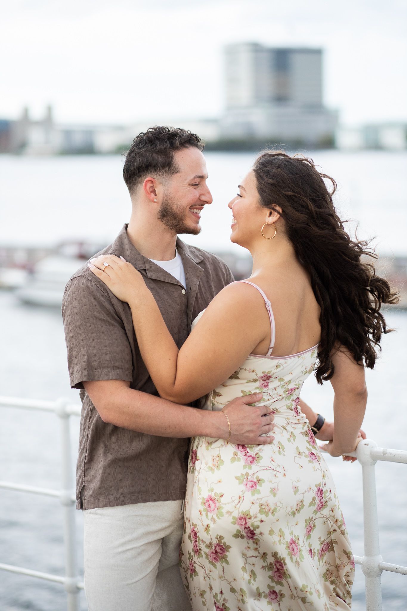 A couple shares a joyful moment together on a rooftop deck in a romantic photo series.