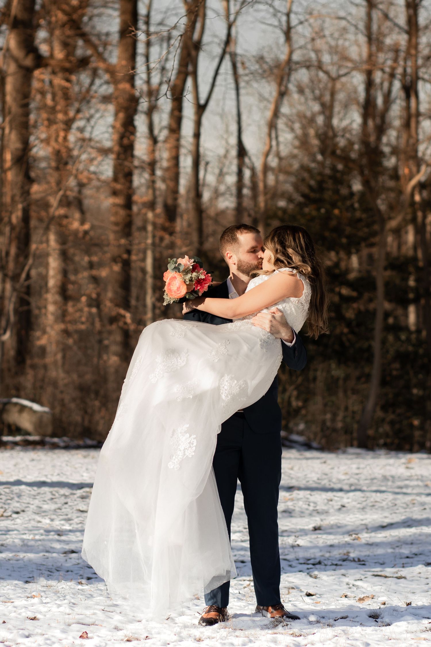 A couple share a romantic dance in the snowy woods during their winter wedding celebration.