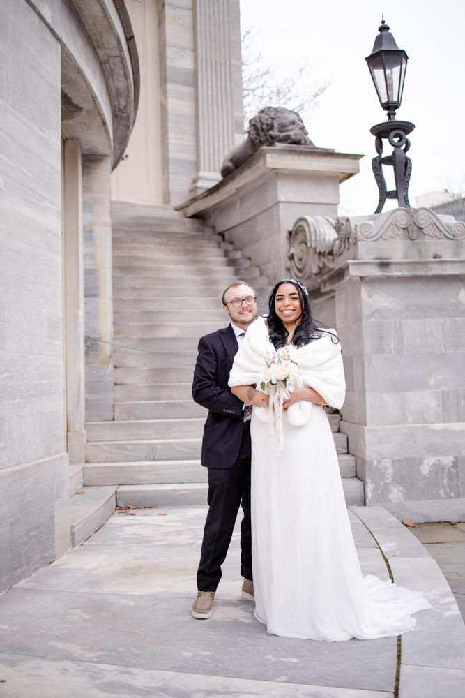 A couple shares a romantic moment among elegant stone columns and archways in this classic wedding photography series.