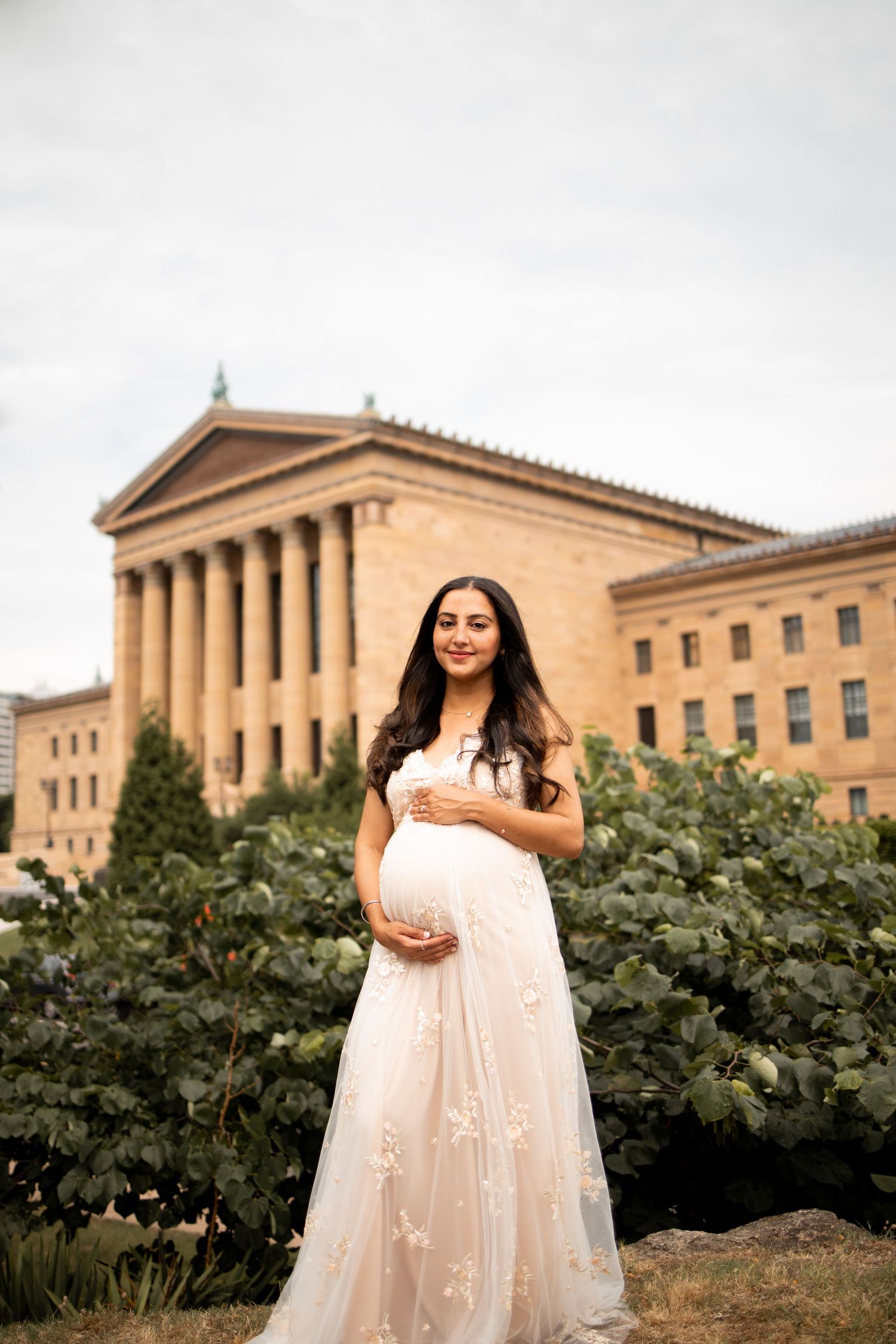 A flowing cream-colored dress photographed outdoors at the Philadelphia Museum of Art with its iconic columns.