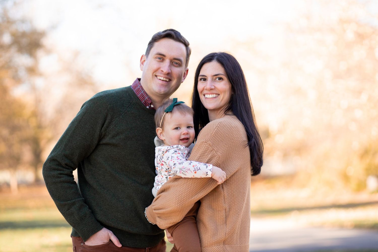 Family photos taken outdoors during golden hour showing loving embraces and joyful moments against a warm sunset backdrop.