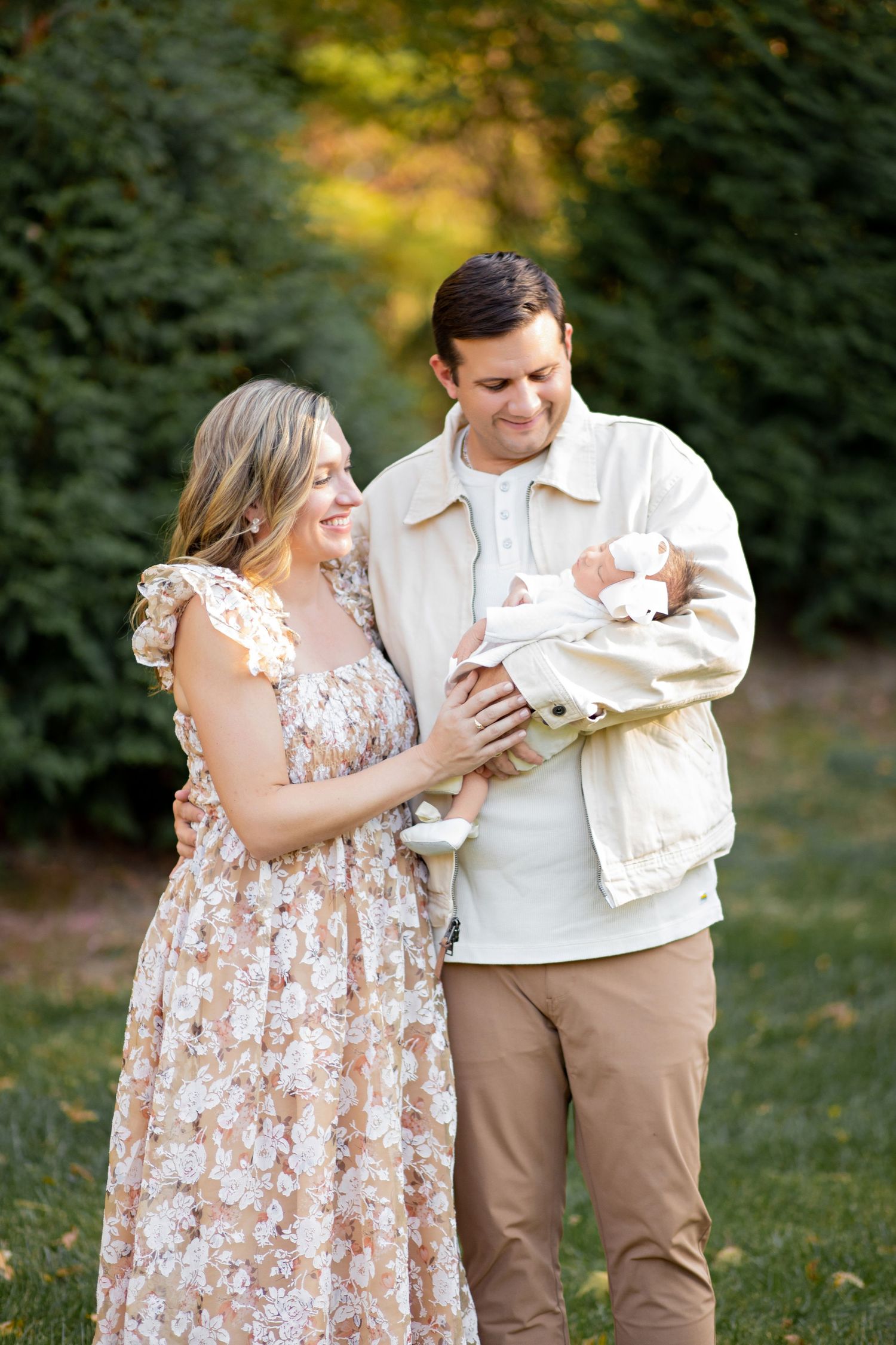 A couple in casual attire share an intimate moment outdoors holding what appears to be an envelope together.