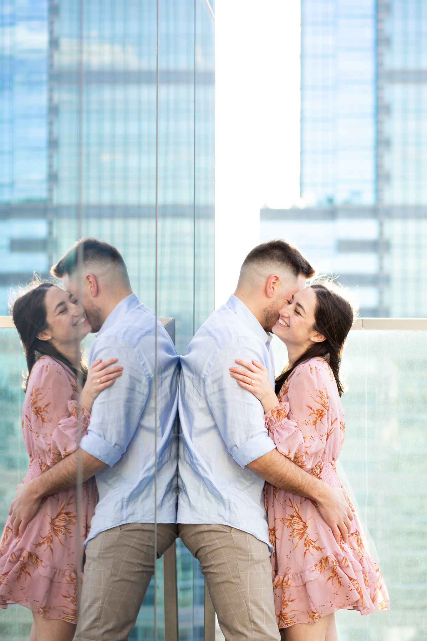 A couple in romantic poses share tender kisses against a bright glass window background.