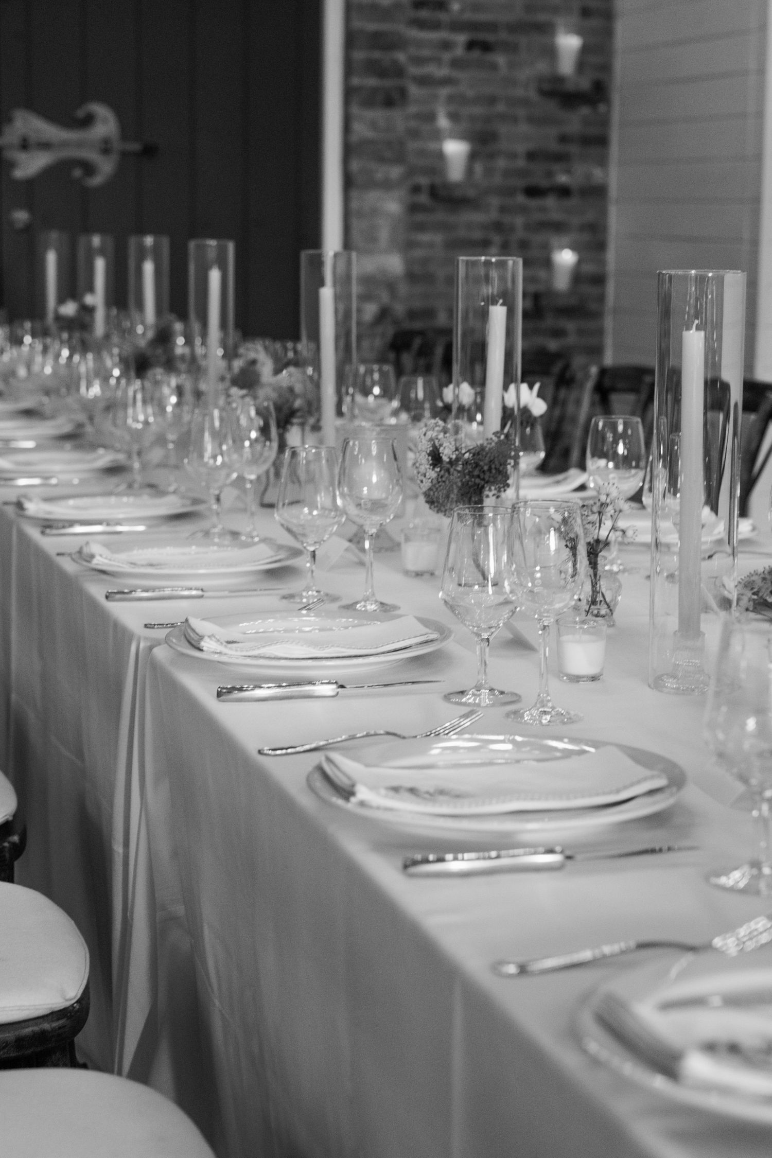 Elegant formal table setting with wine glasses, plates, and silverware arranged on a white tablecloth.