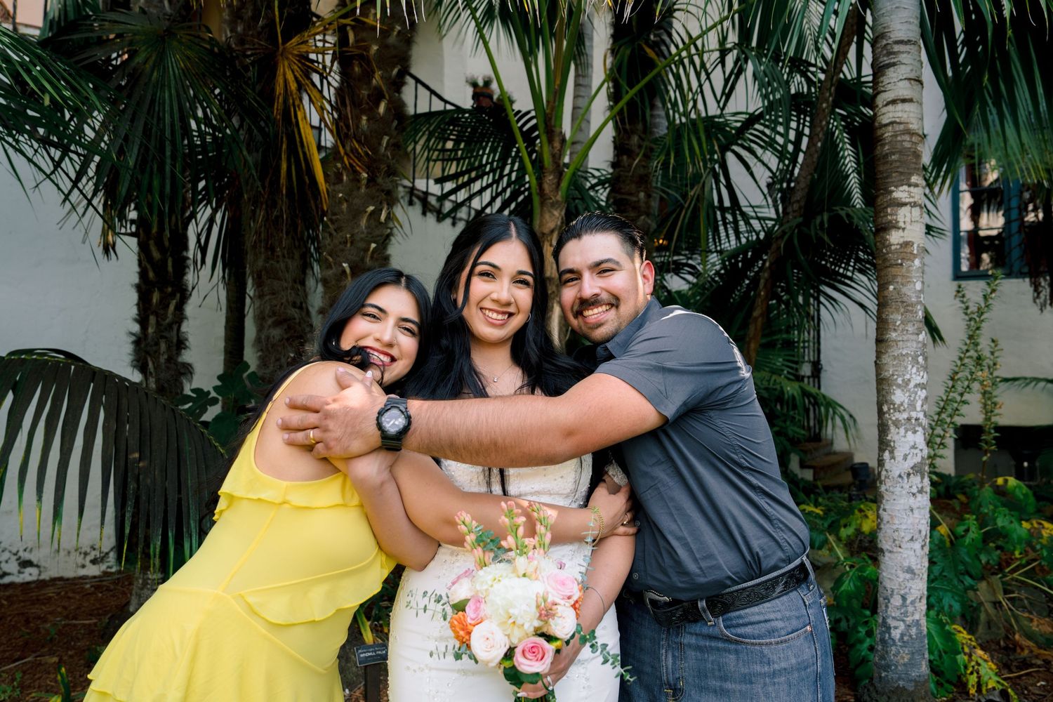 Candid wedding party photos showing joyful embraces in a tropical garden.