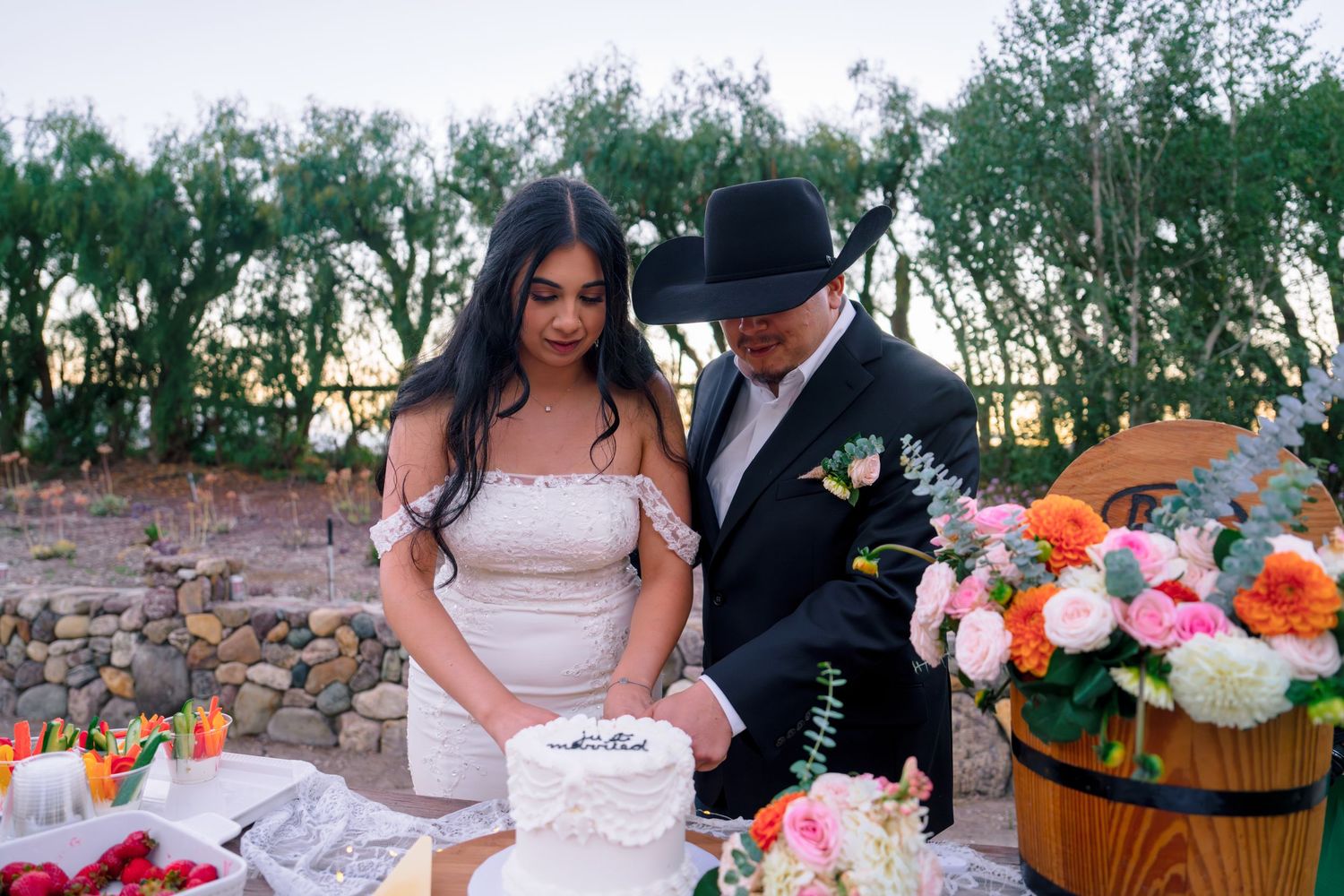 Wedding reception celebration with decorated tables and floral arrangements outdoors.