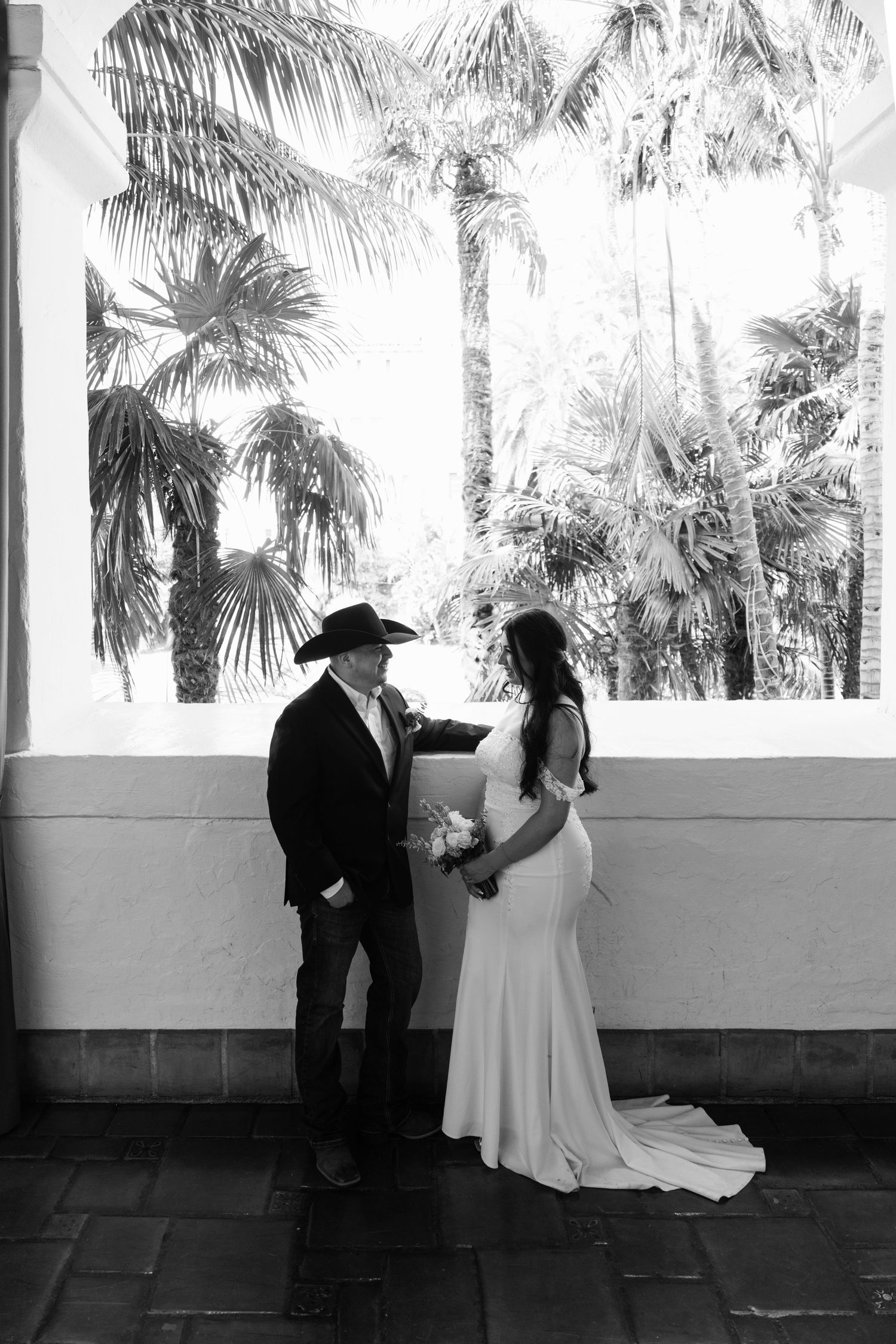 Black and white wedding photos showing a couple posing against a backdrop of palm trees.
