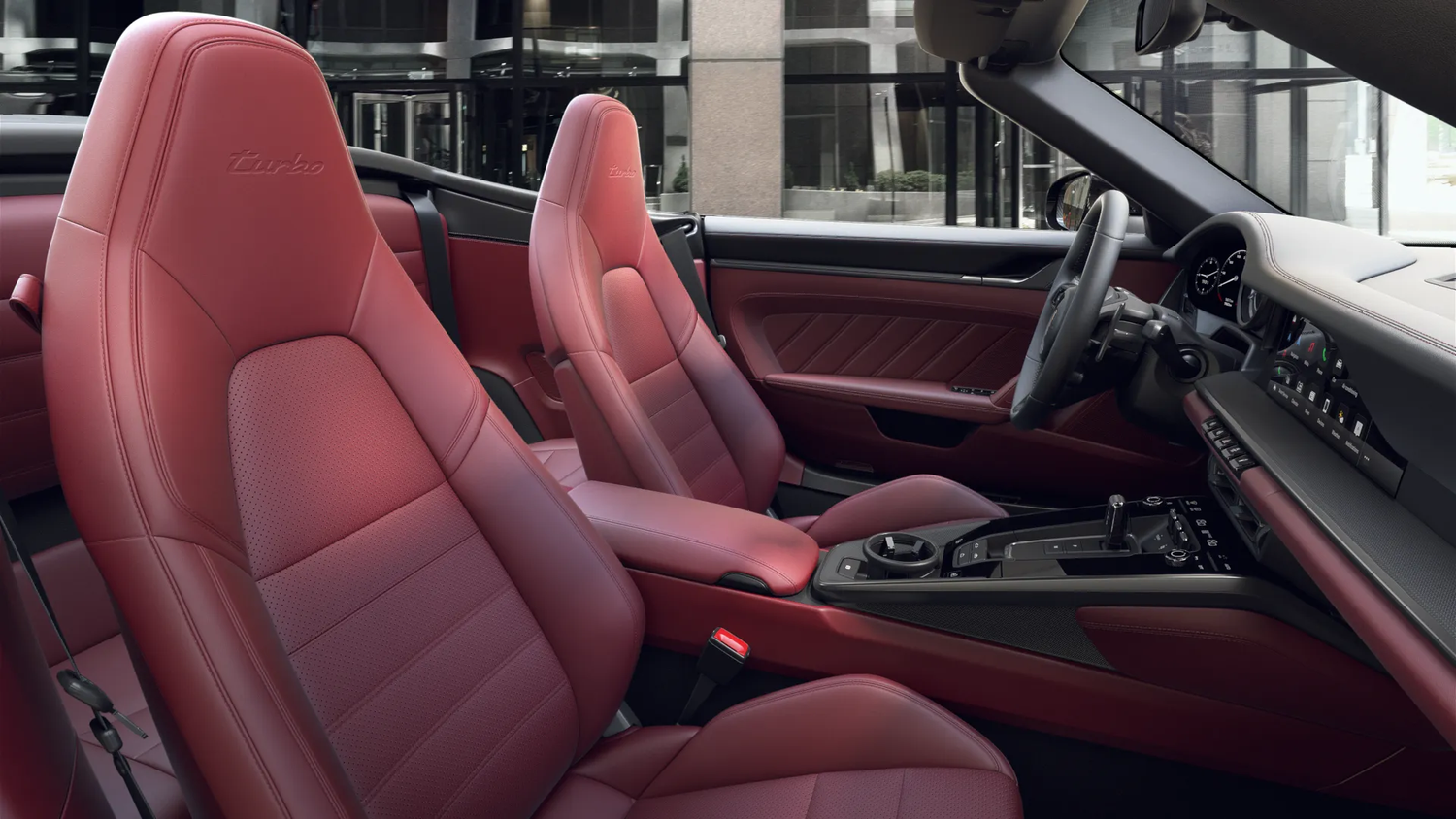 Luxury Porsche 911 Turbo interior featuring deep red leather seats and modern dashboard controls in multiple views.