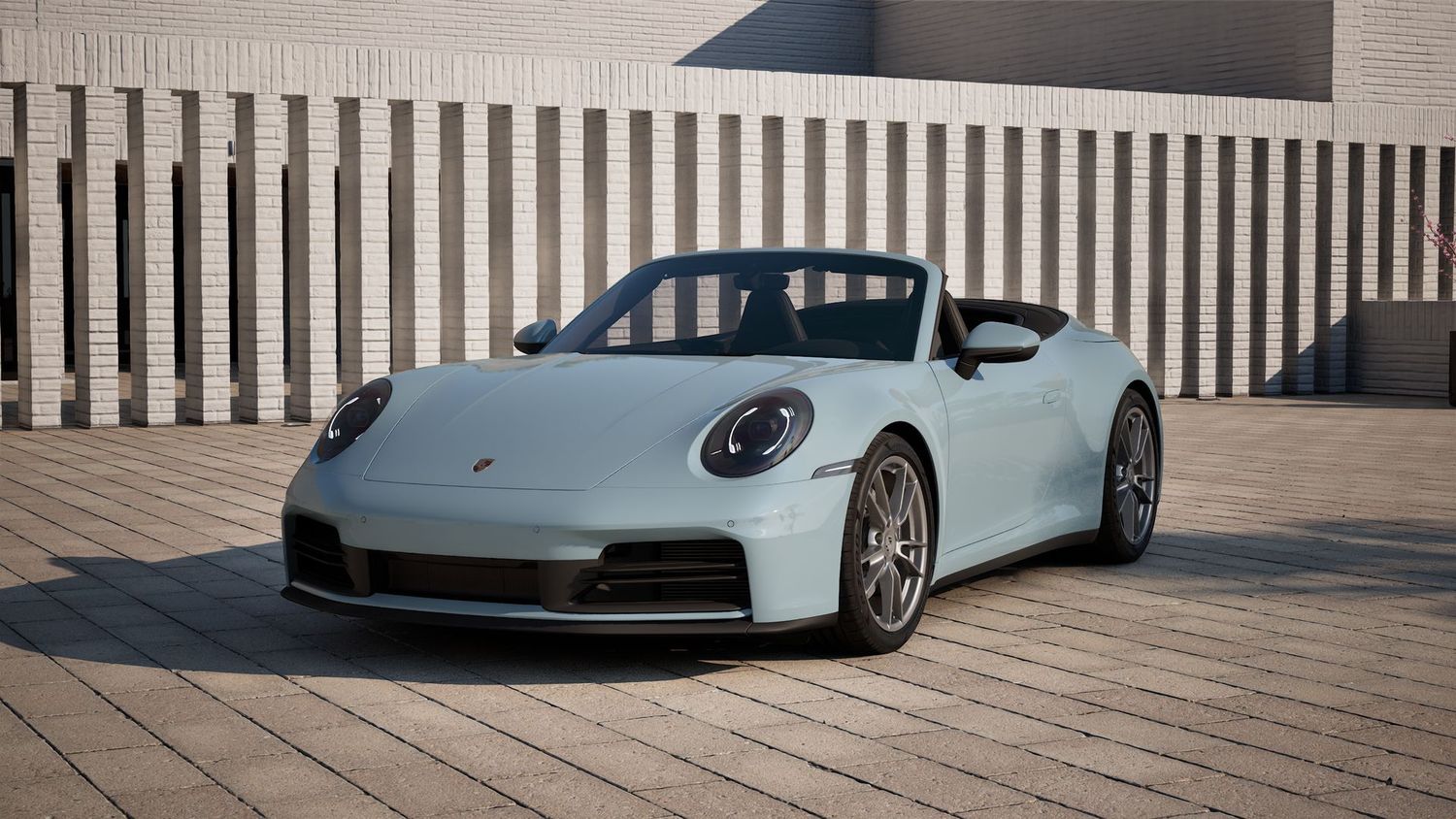 Sleek silver Porsche 911 showcases its signature profile and LED taillights against a modern architectural backdrop.