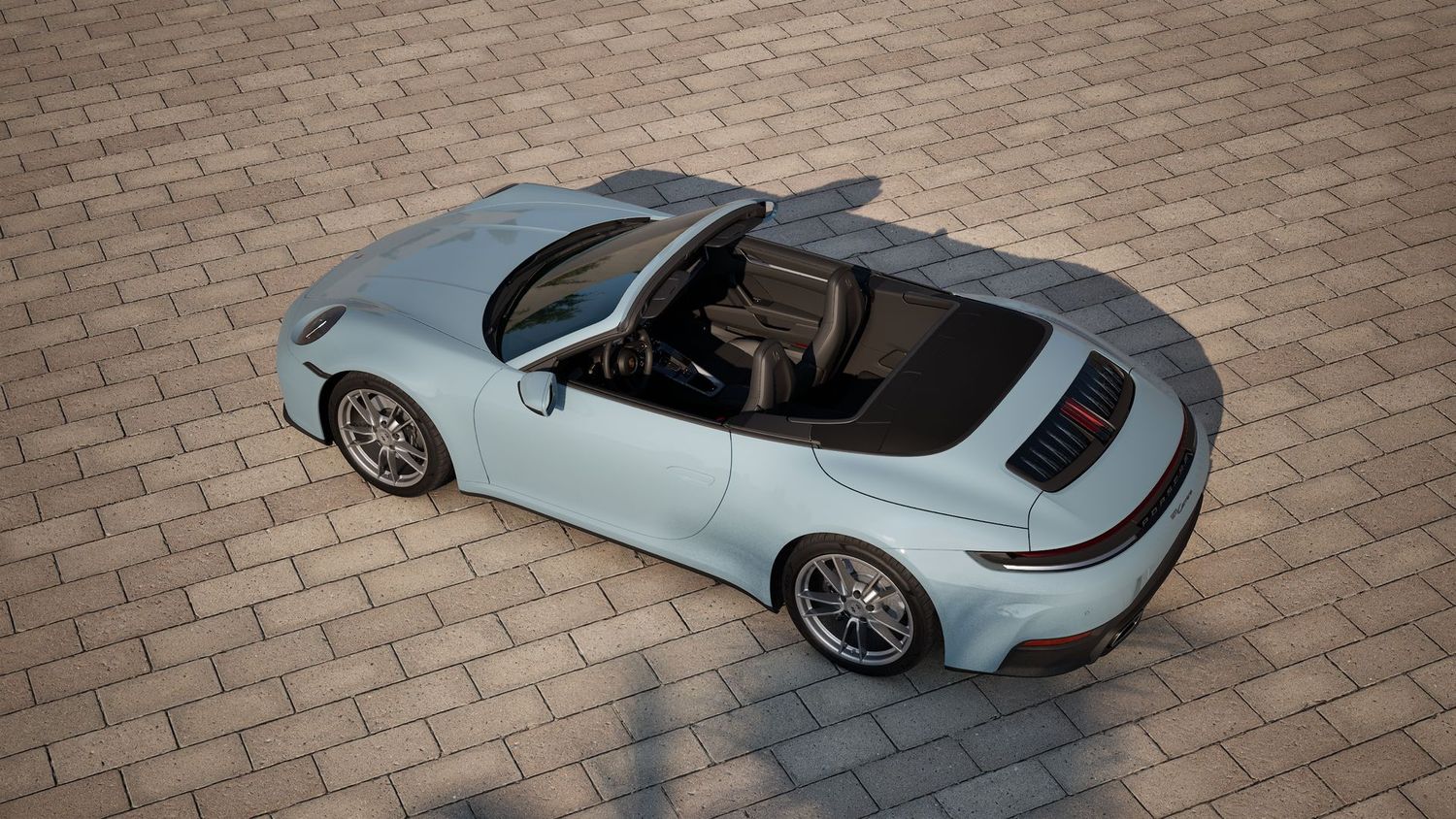 Side view of Porsche 911 showcasing its sleek profile and elegant design on brick pavement.