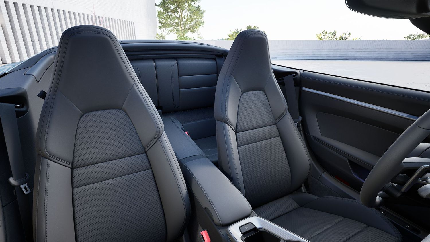 Black leather sport seats in a Porsche 911 interior showing front bucket seats and partial rear bench seat view.