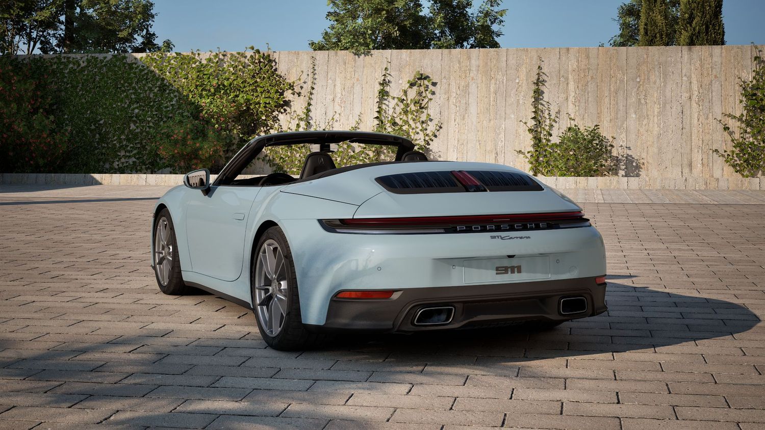 Several views of a light blue Porsche 911 are displayed on a stonstone-pavedrtyard near manicured landscaping.