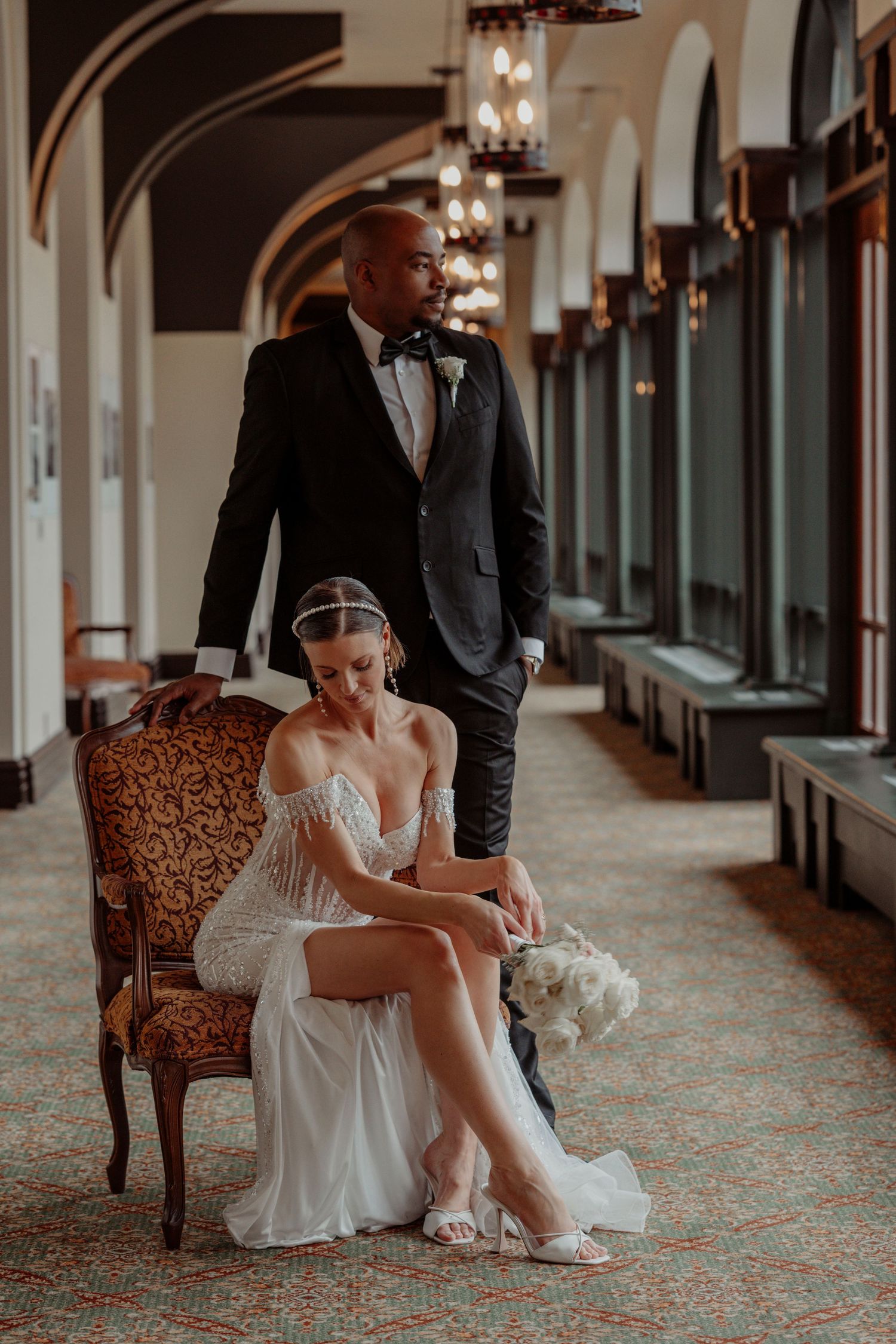 couple mariage,manoir richelieu avec style sur ue chaise et dans le corridor ,journnée grise