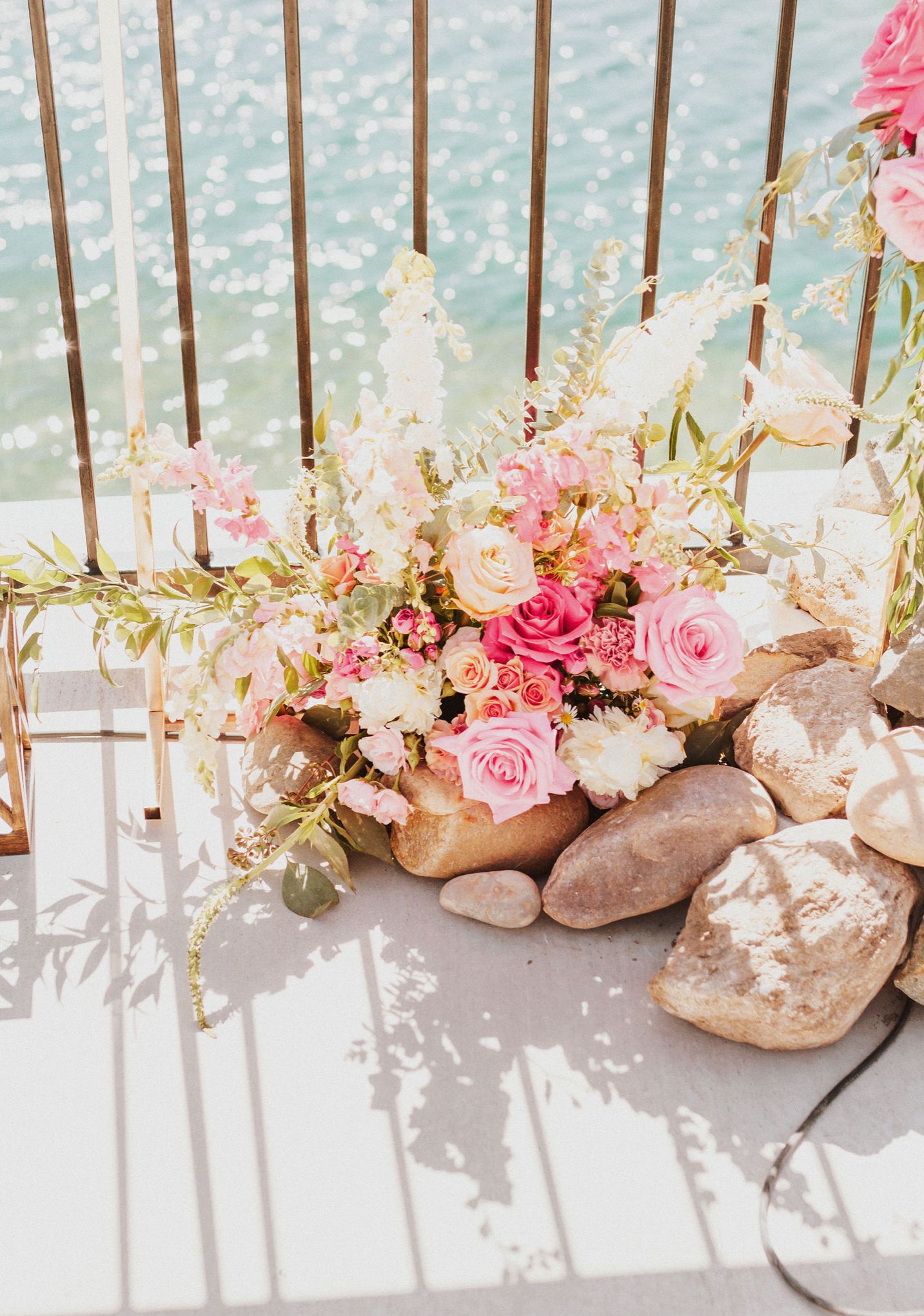 Pink roses and floral decorations arranged with stones creating an elegant border display.