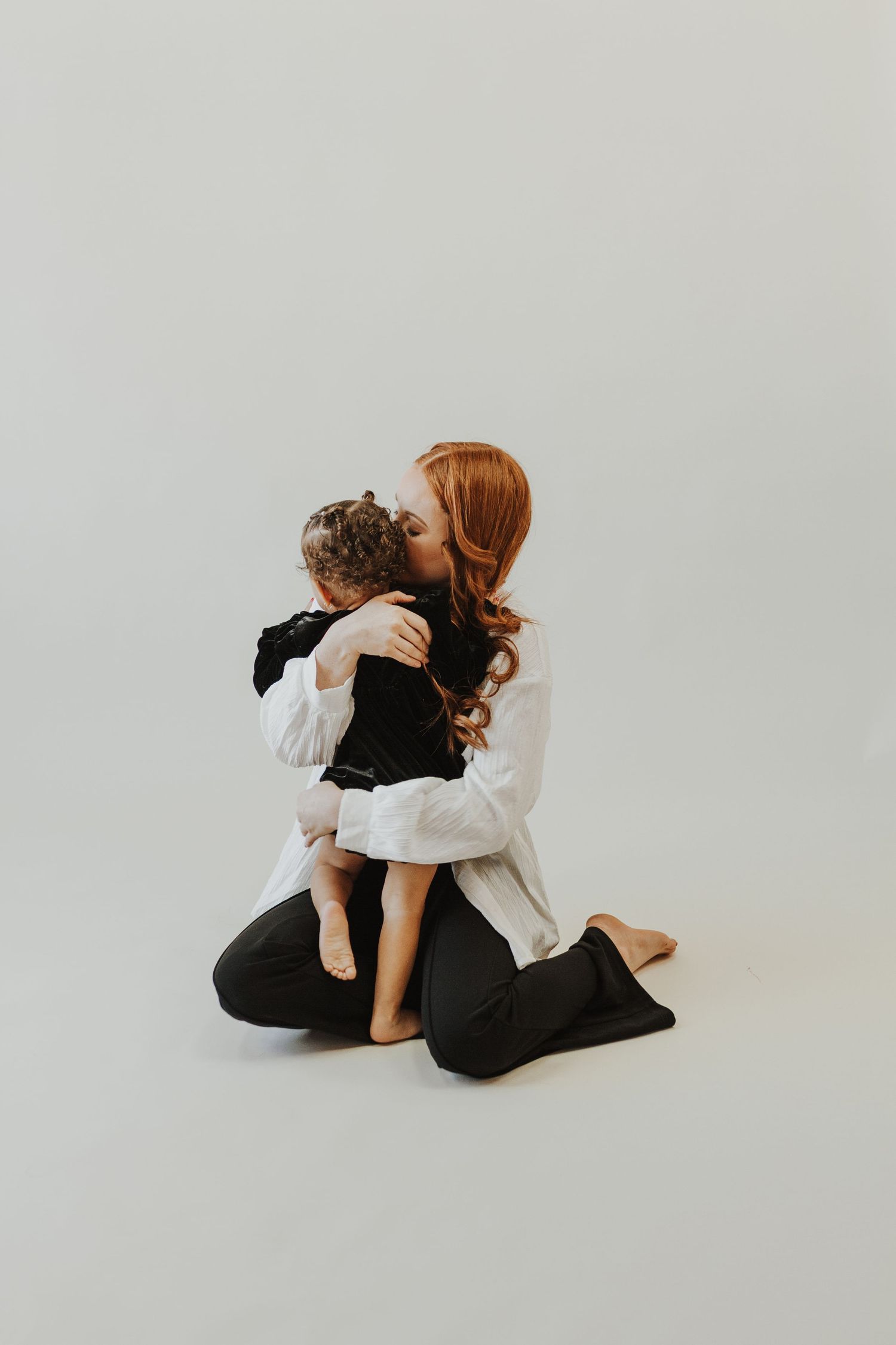 Artistic intimate portrait session against minimal white background.
