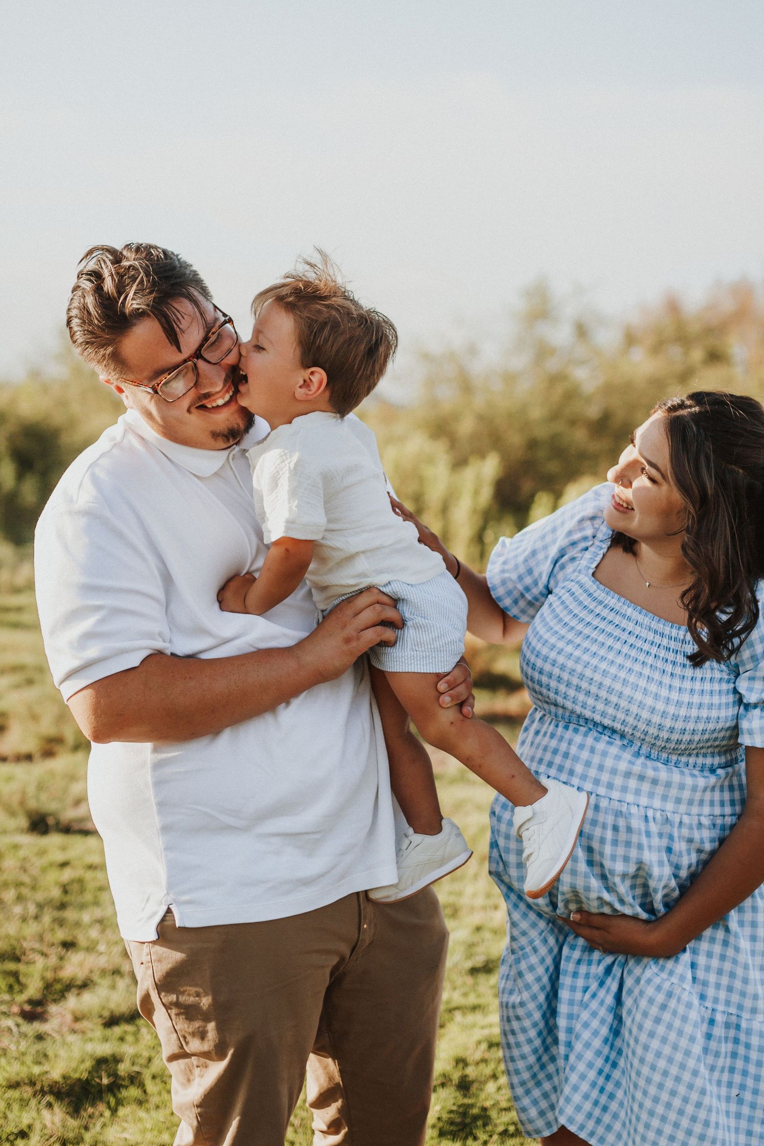 Family in coordinating white and blue outfits sharing joyful moments outdoors.