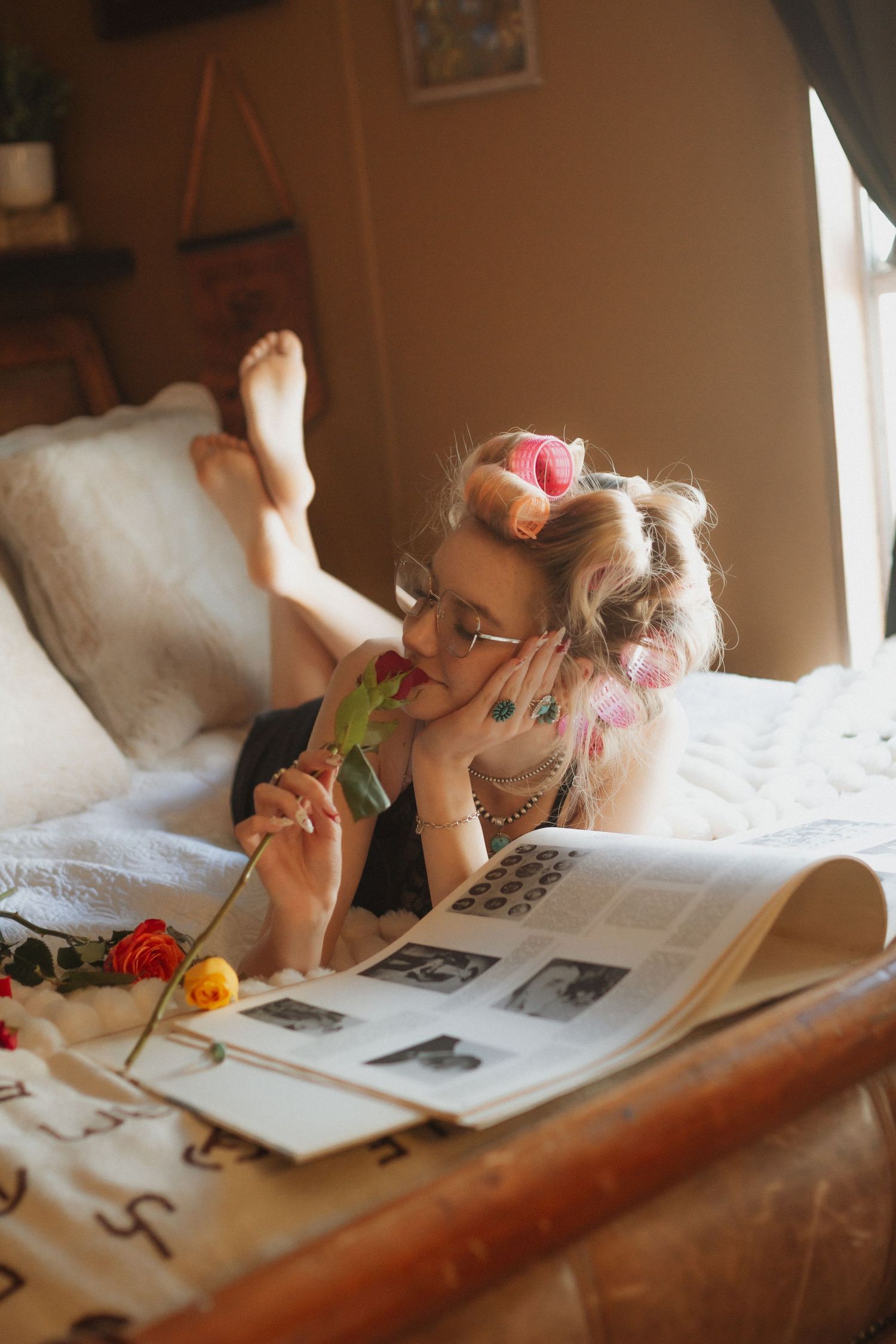 A person reading and taking notes while lying down in soft natural lighting.