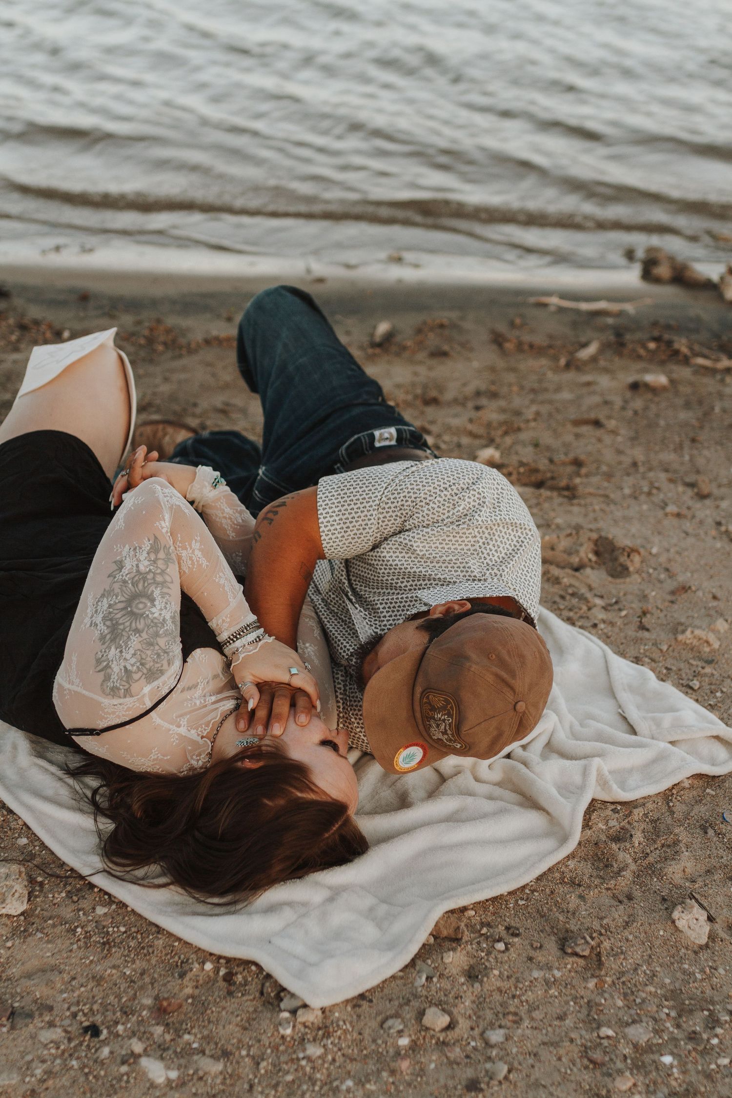 Intimate couple's portrait session on sandy beach at sunset.