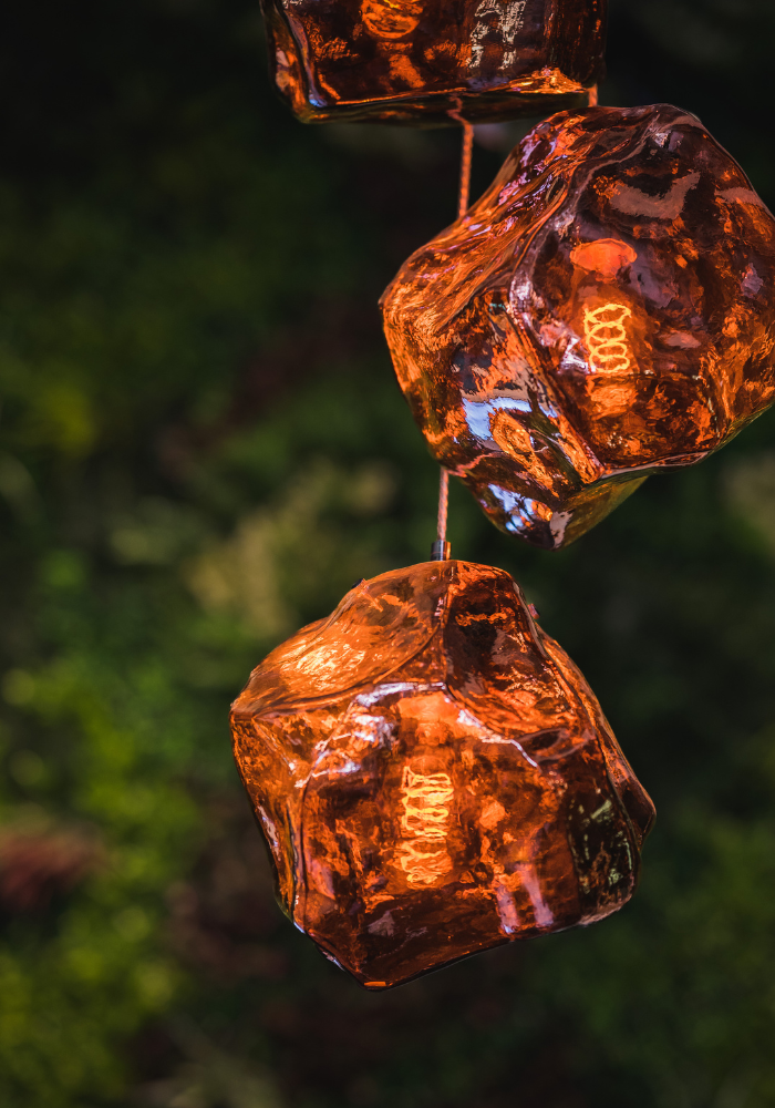 Glowing amber glass pendant lights creating warm atmospheric lighting against dark background.
