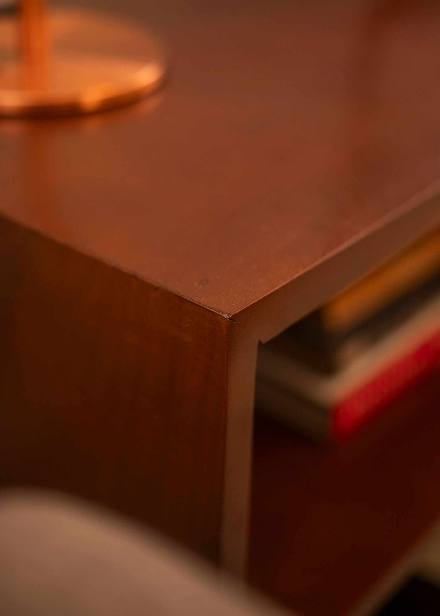 Close-up detail of wooden furniture edges in warm amber lighting.