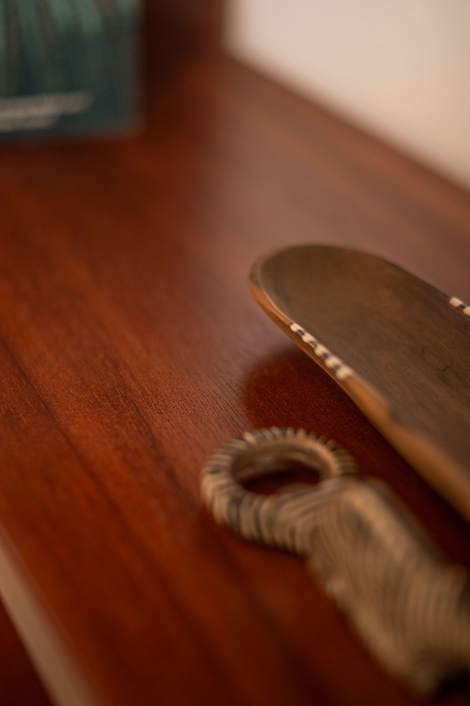 Close-up shot of a skateboard deck and hair tie on a dark wooden surface.