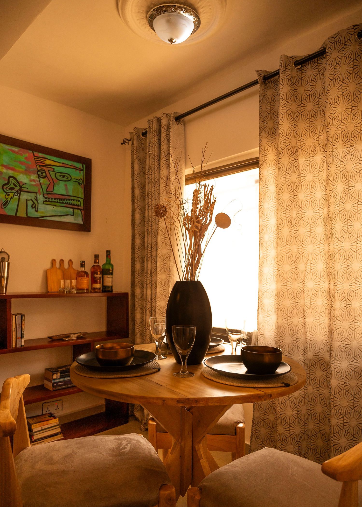 Cozy living room interior with ambient lighting, patterned curtains and modern decor elements.