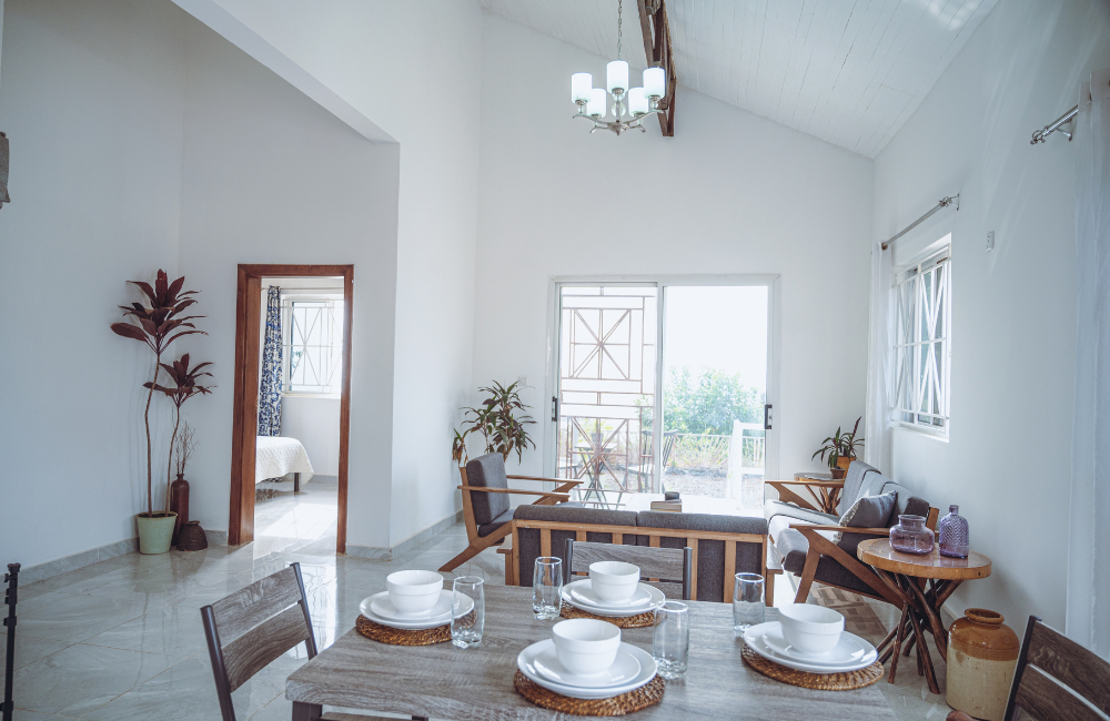 Bright dining space with table settings and mid-century modern furniture under vaulted ceiling.