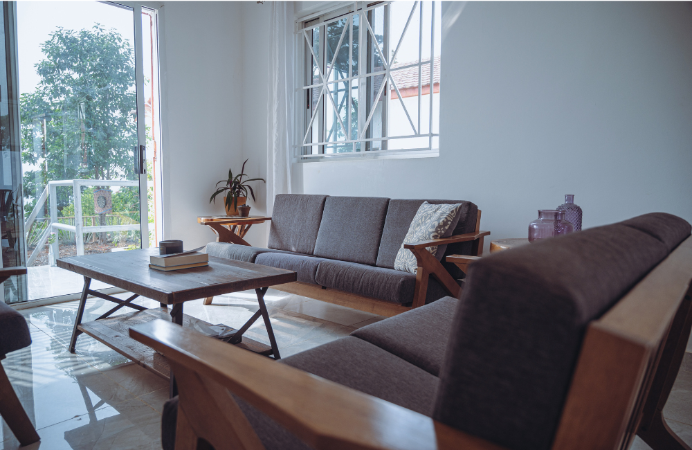Minimalist living space with brown sofas and coffee table arranged around large windows.