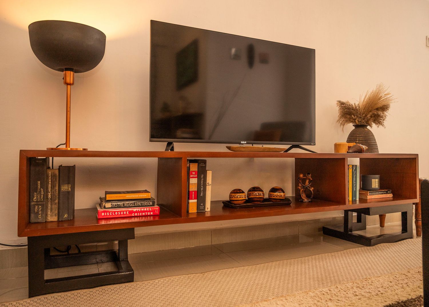 Modern living room setup with floating wooden shelves and a flatscreen TV mounted on the wall.