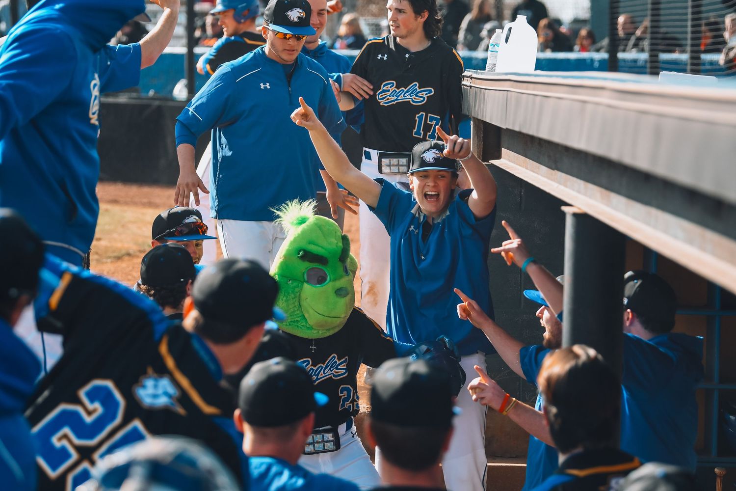 baseball team celebrating, one players wearing a grinch head.