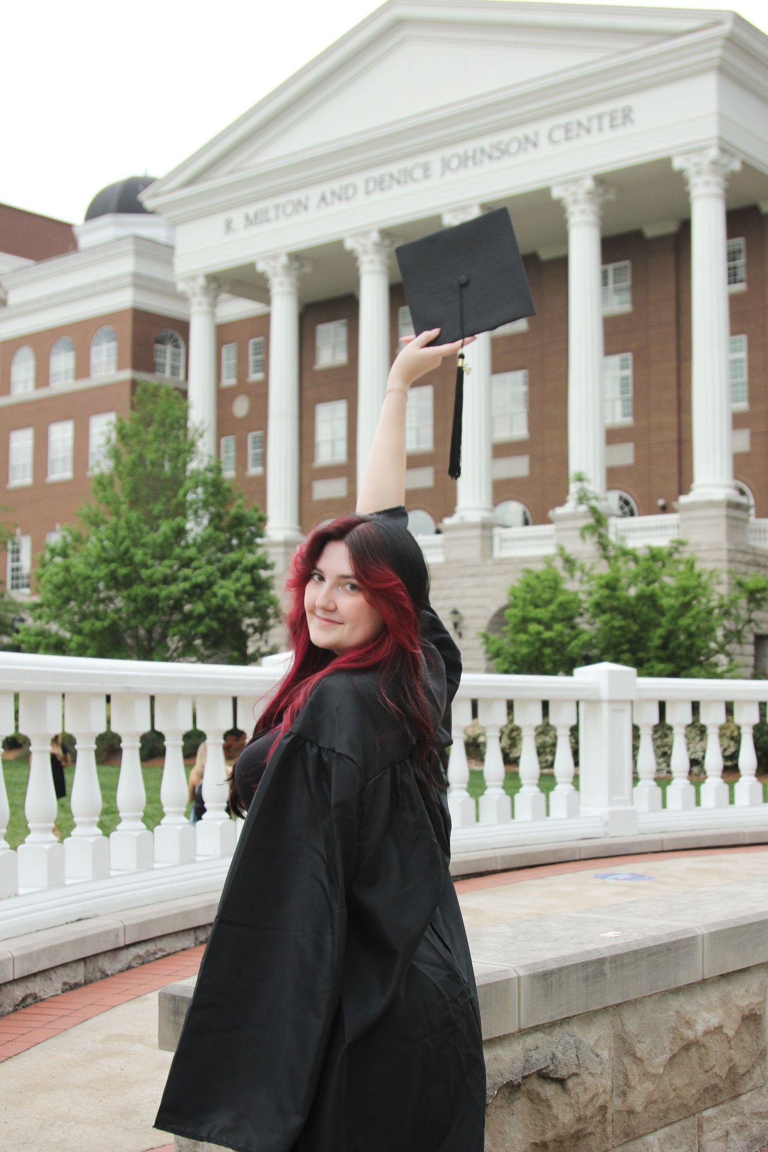 Graduation photos taken in front of a grand collegiate building with white columns.