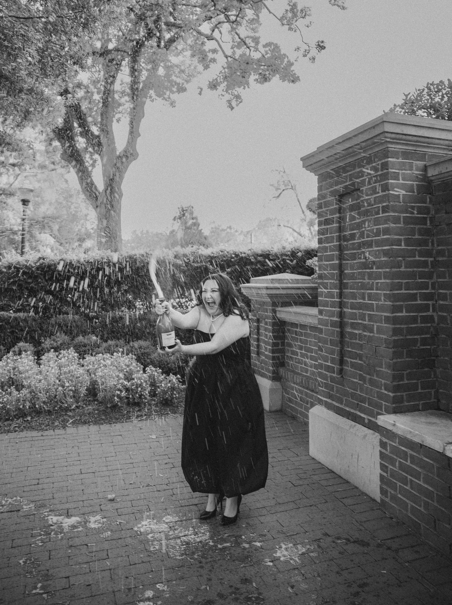 A black and white photo of someone in a dress playing in the rain.