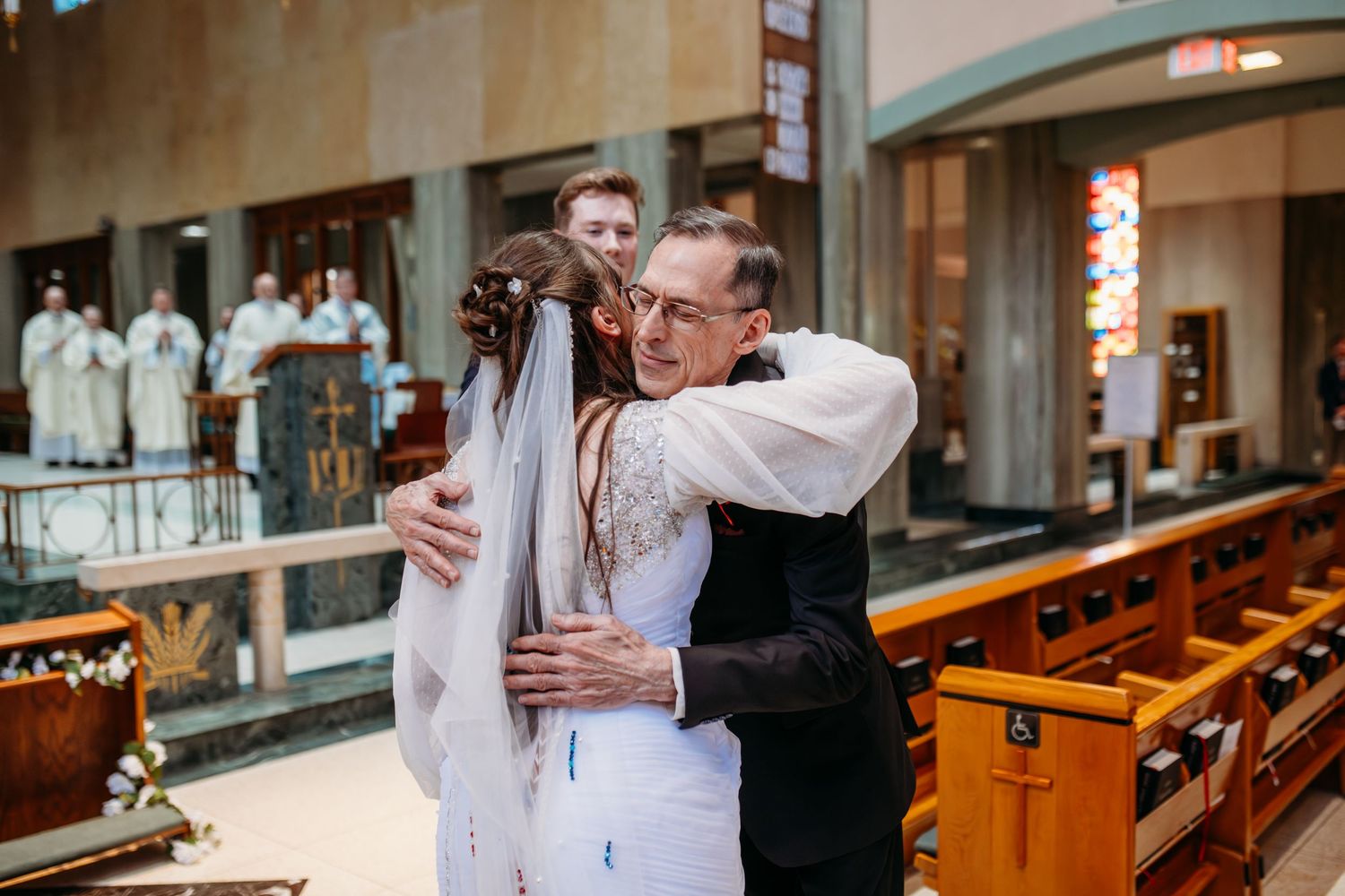 A church wedding with the newlyweds embracing at the altar as family and friends celebrate the joyous occasion.