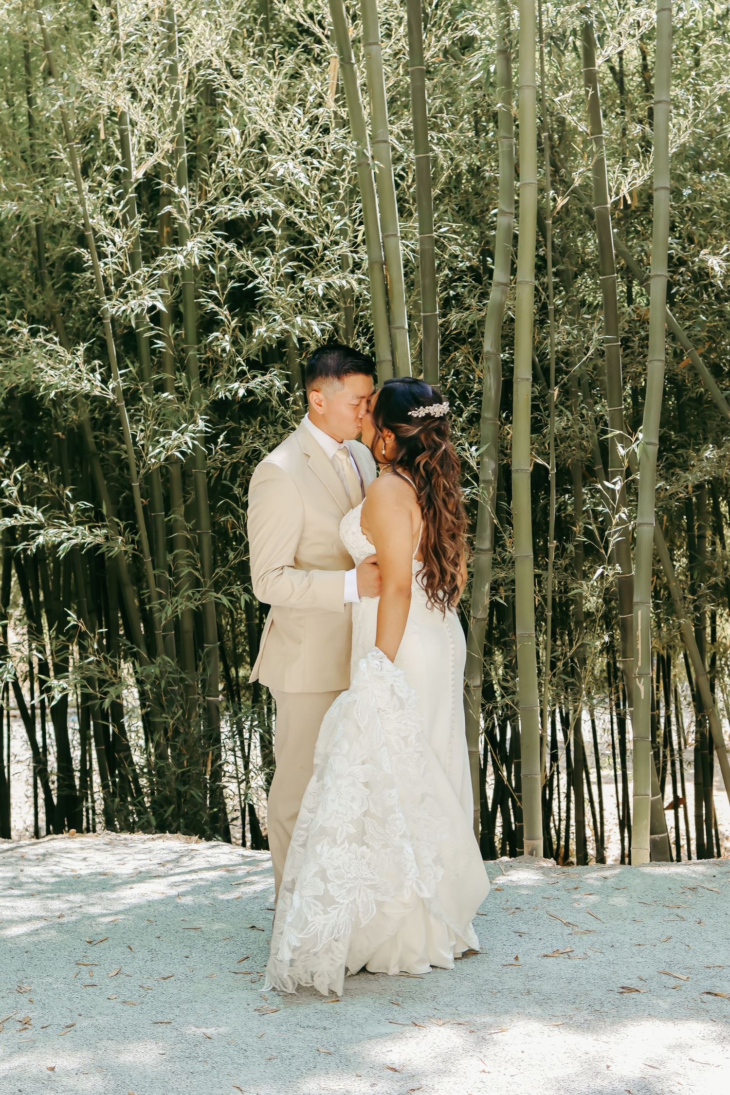 A romantic wedding photo with couple standing in front of a bamboo forest.