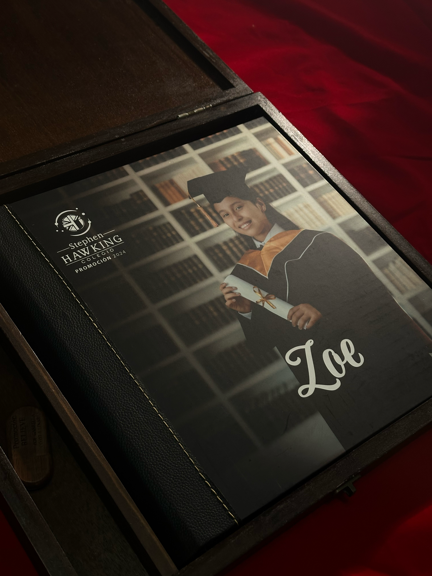 A series of black photo album or portfolio book covers shown at different angles on a dark red background.