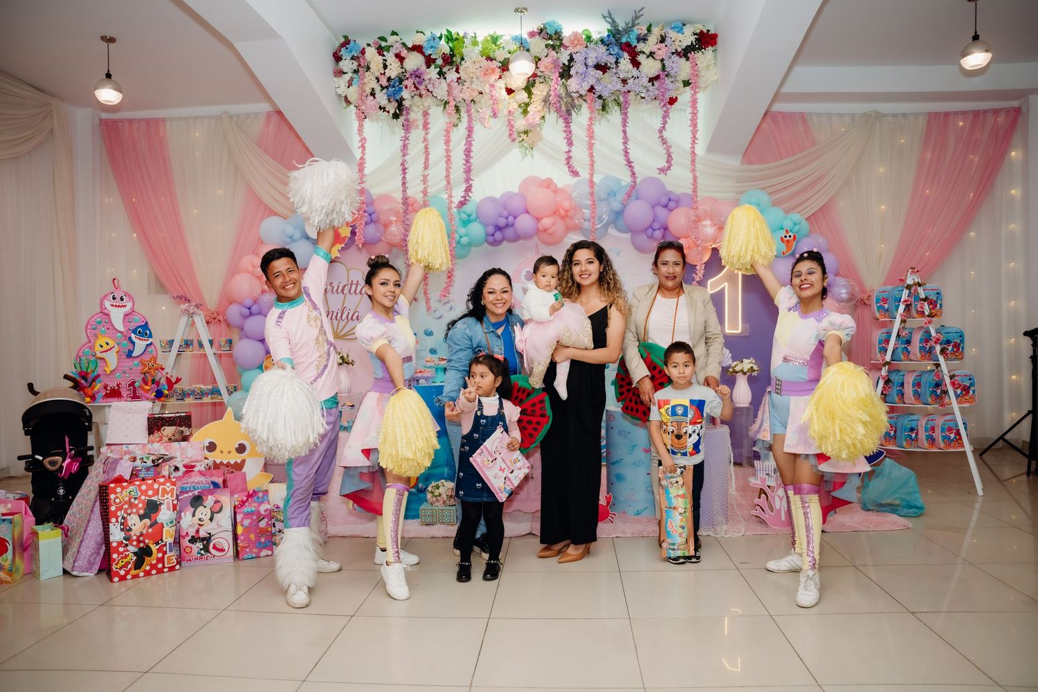 A colorful gallery space decorated with vibrant artwork and balloons for a special event.