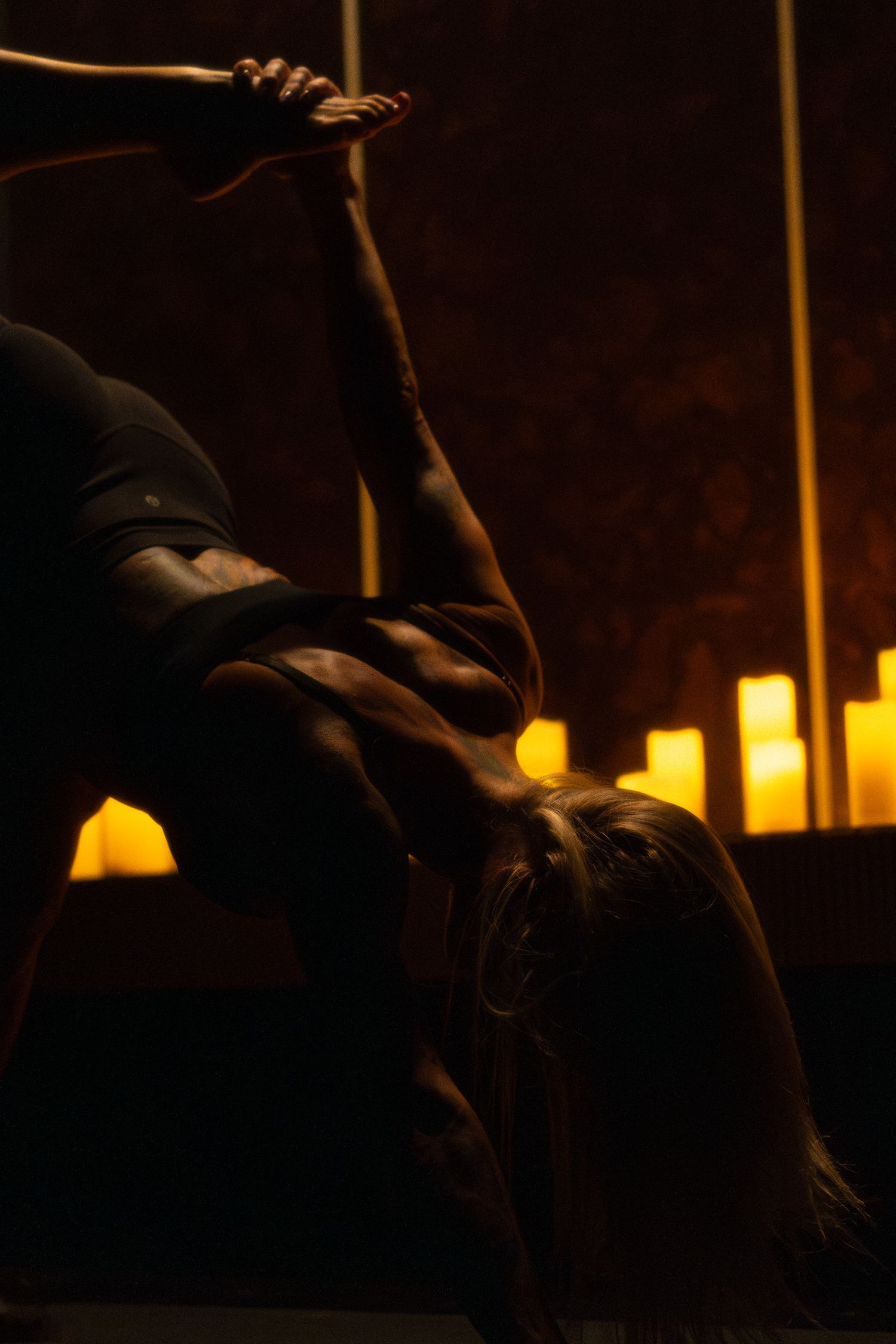 Graceful dance movement captured in warm candlelight with dramatic shadows.
