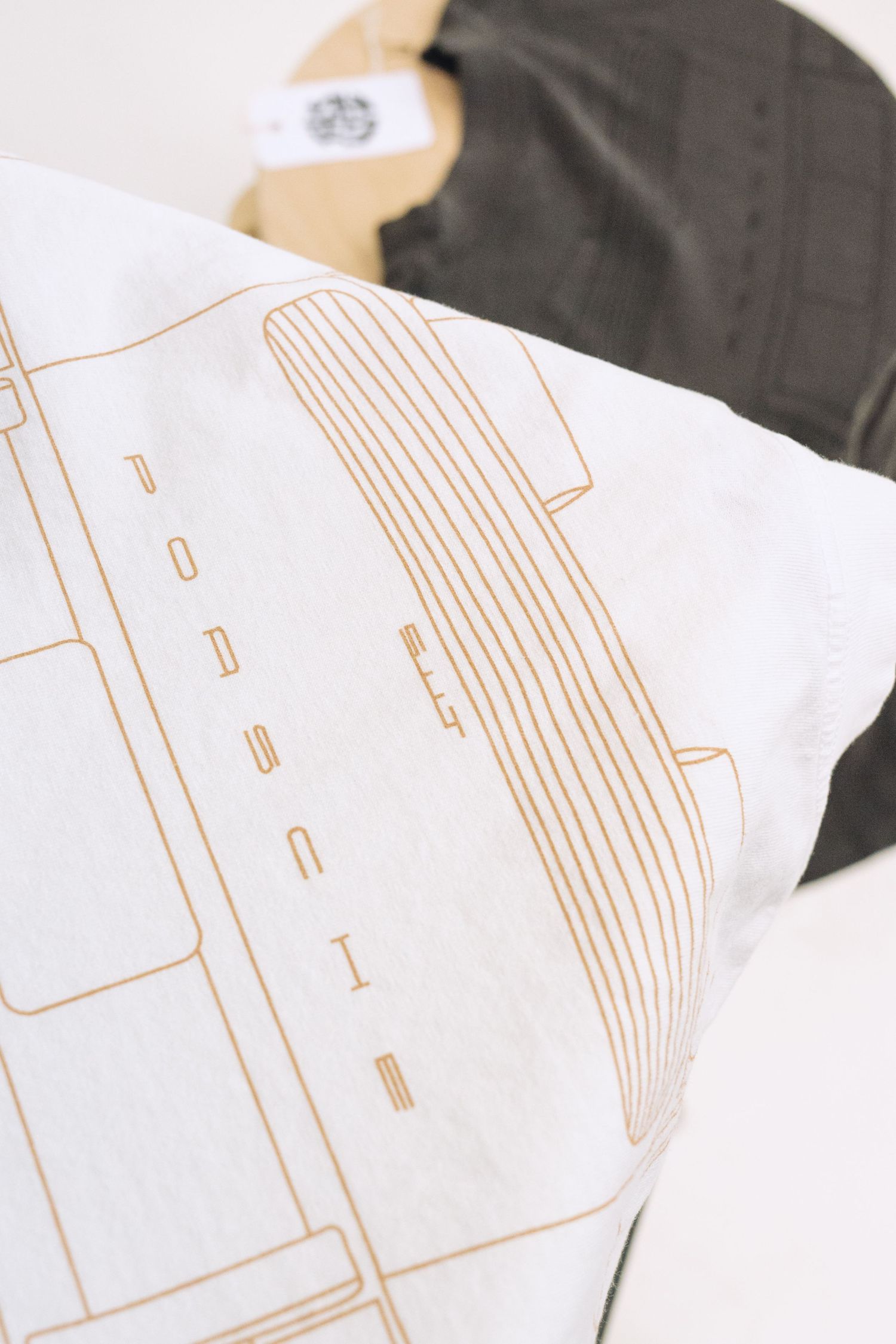 White t-shirt with minimalist gold line drawing design.
