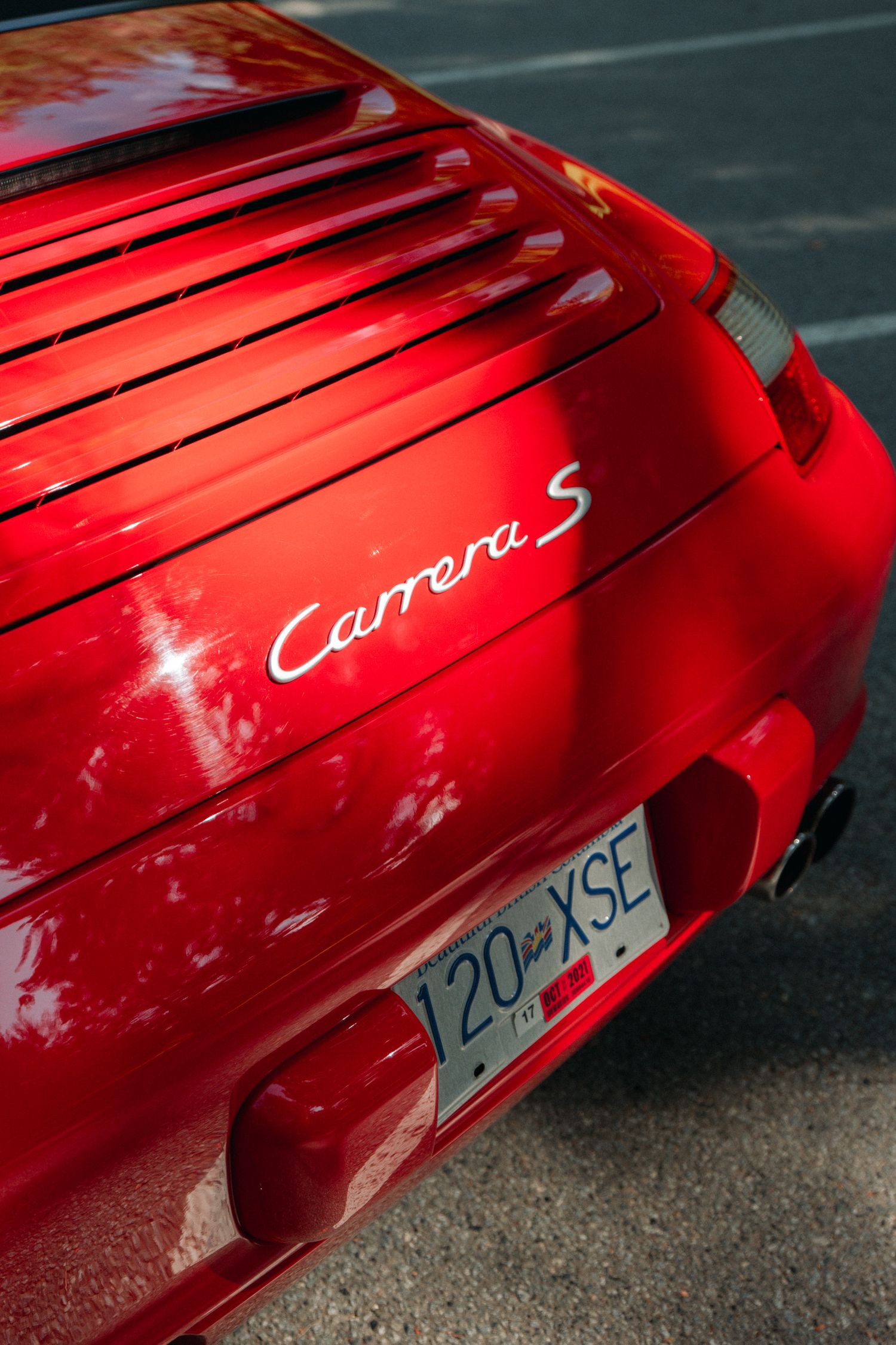 Close-up of a red Porsche Carrera S badge and rear grille detail.