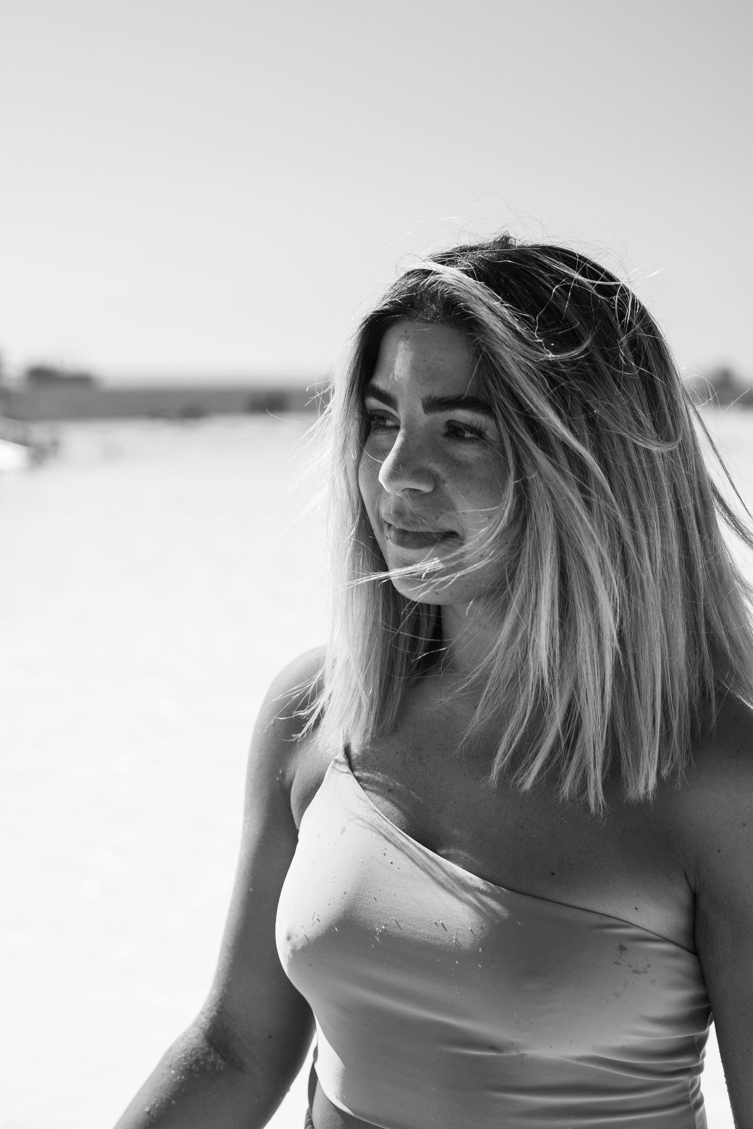Black and white portrait with soft natural lighting on beach.