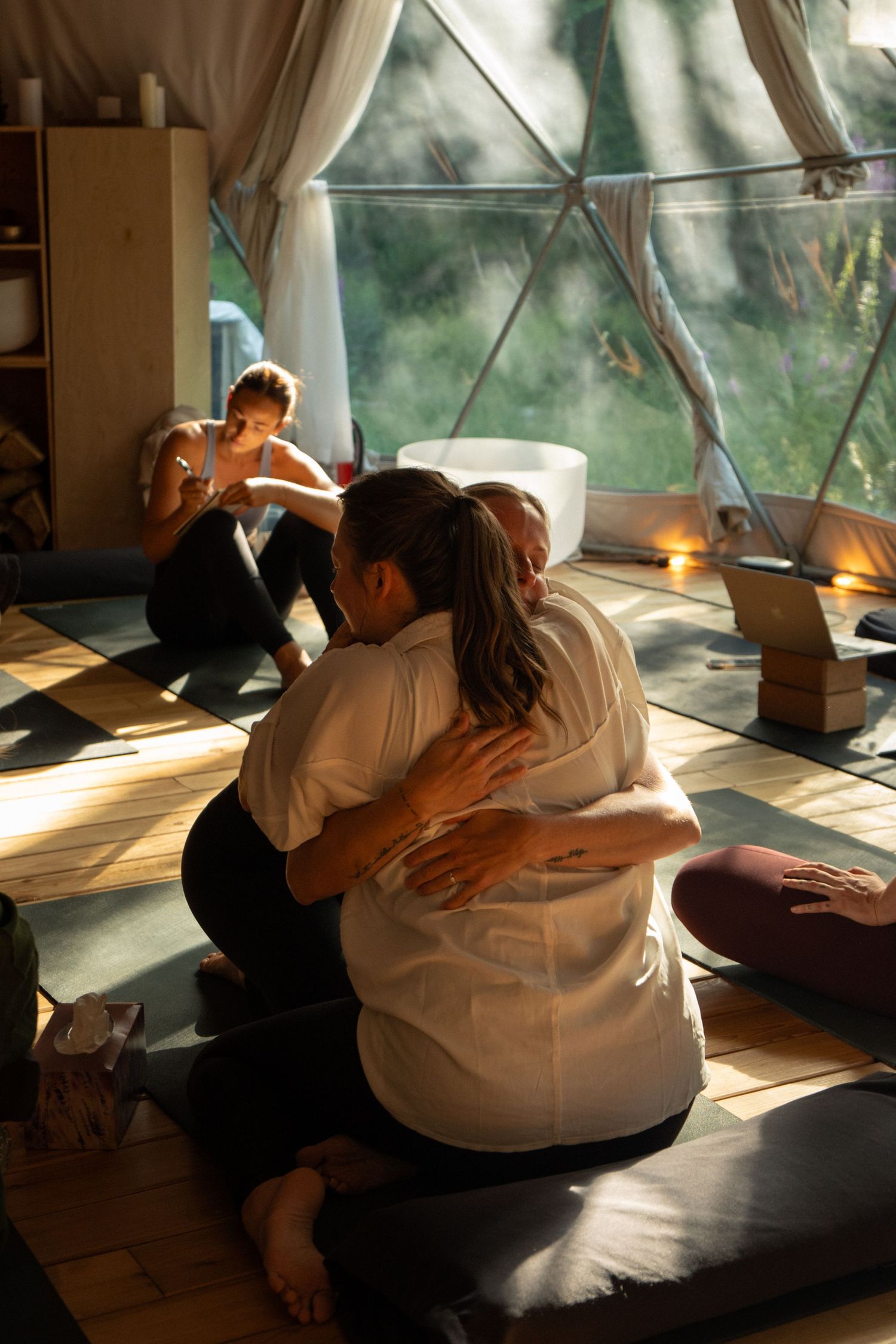 Students practicing partner yoga exercises in a sunlit dome studio with geometric windows.