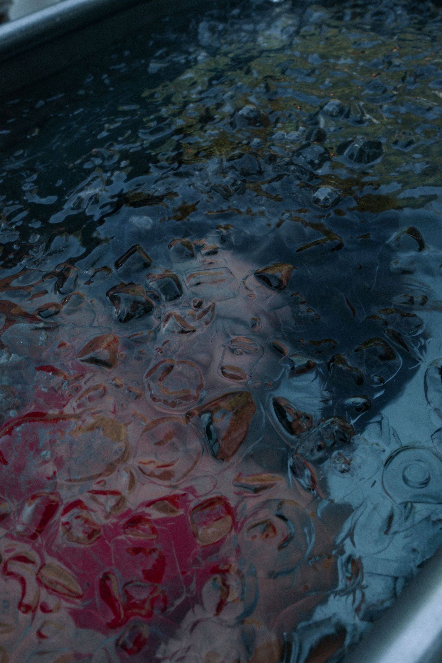 Abstract pattern of water ripples with blue and pink color reflections.
