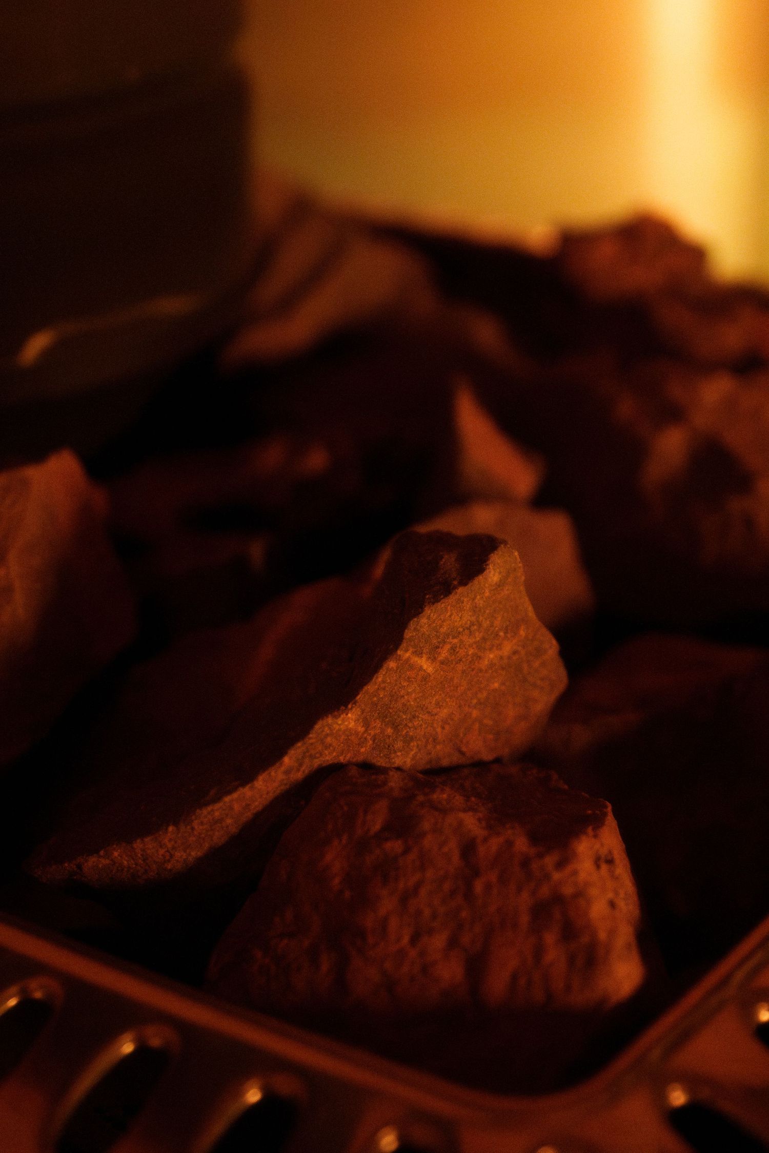 Close-up of hot rocks or stones in sauna setting.
