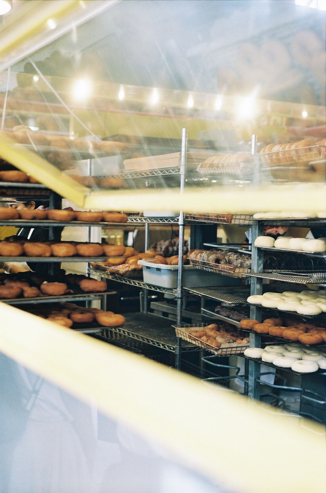 Bakery display shelves filled with fresh bread and pastries in warm lighting.