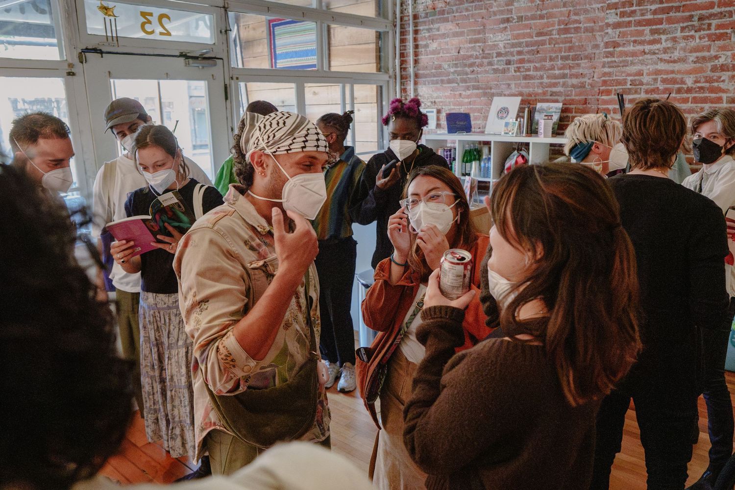 A crowded indoor event space with people wearing face masks during the pandemic.