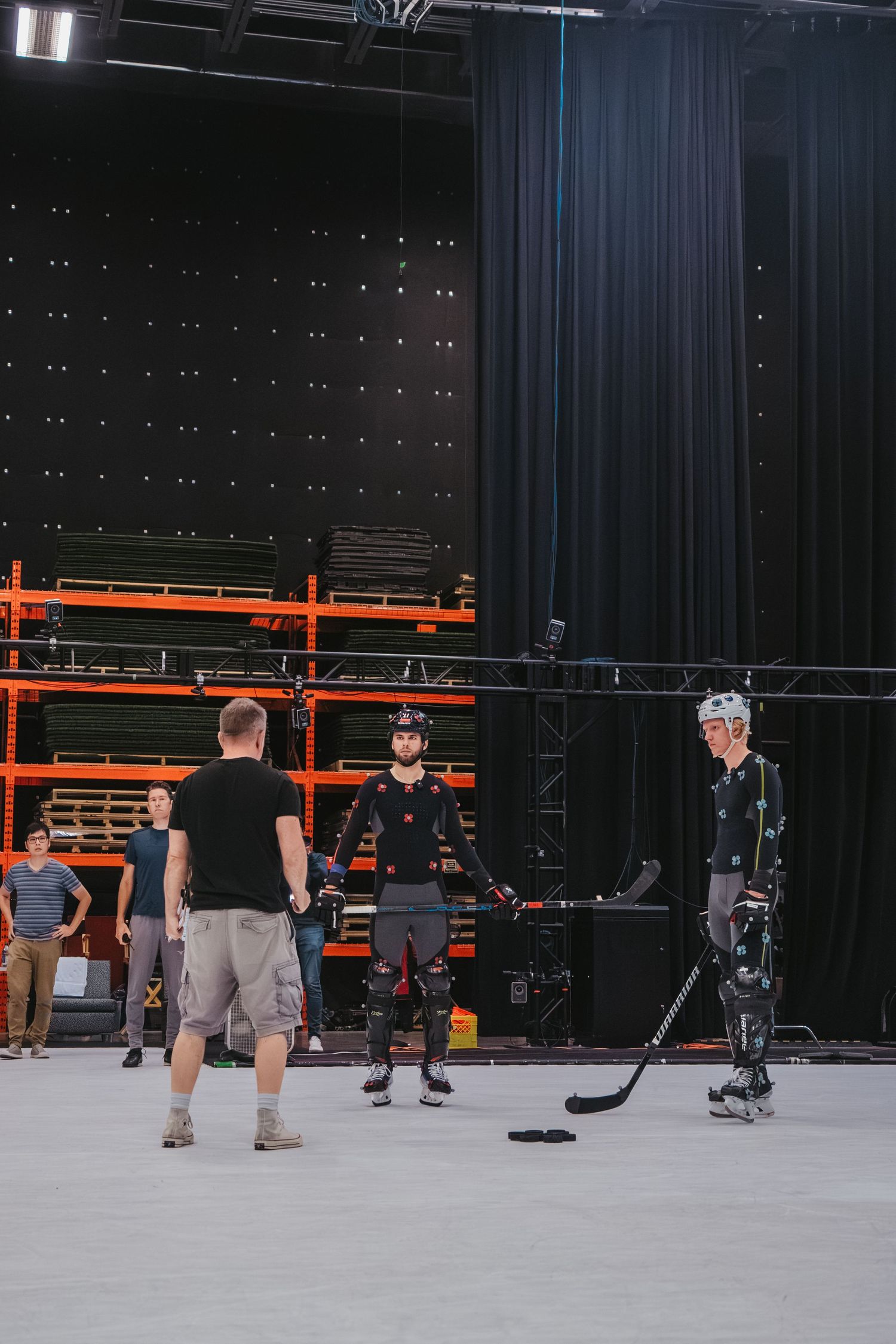 Motion capture session for hockey players with technical crew visible in studio setting.