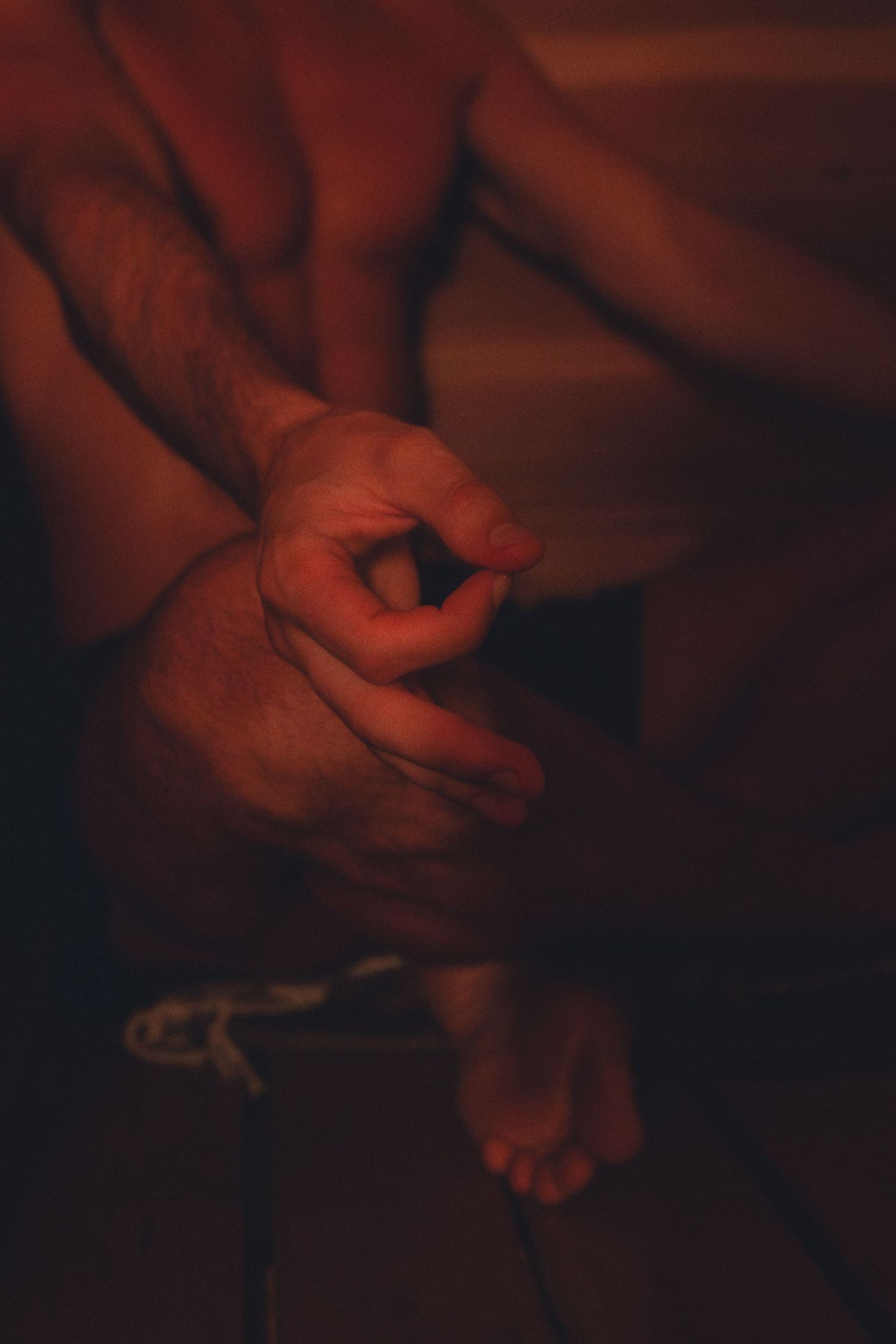 Close-up of hands in warm, moody lighting creating artistic shadows.