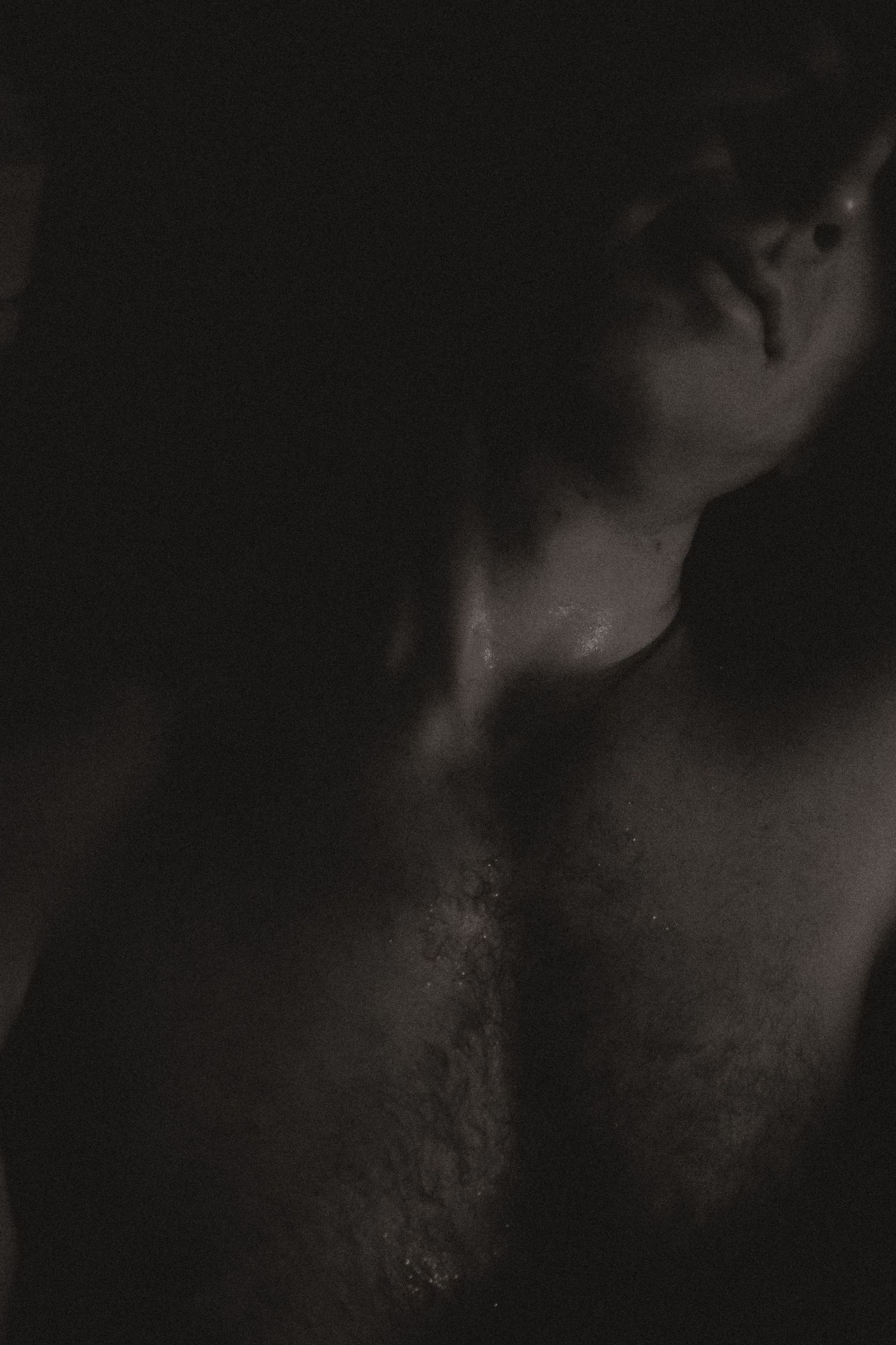 Artistic black and white portrait with dramatic shadows and lighting creating a moody atmosphere.